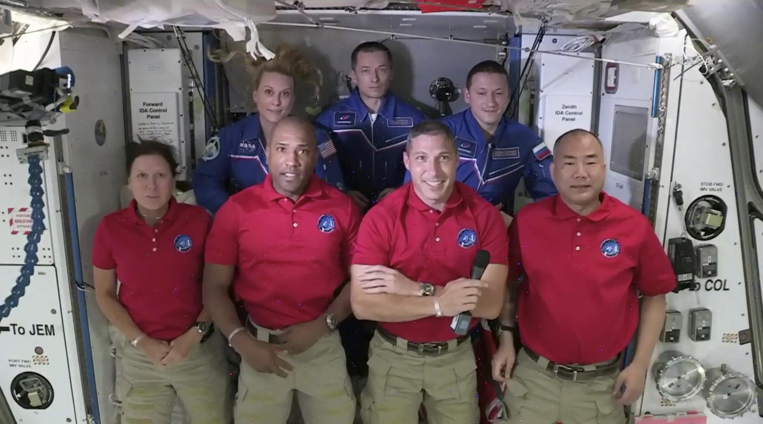 La tripulación de la cápsula Dragon de SpaceX formada por (de izquierda a derecha) Shannon Walker, Victor Glover, Mike Hopkins y Soichi Noguchi, posa con la astronauta Kate Rubins y los cosmonautas Sergey Ryzhikov y Sergey Kud-Sverchkov, que ya estaban en la EEI, durante un acto de bienvenida.