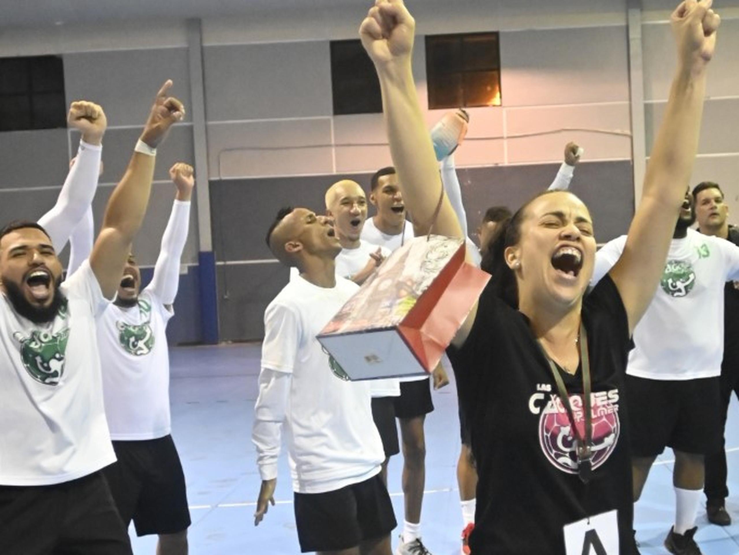Jackeline González Natal celebra, con los Caciques de Palmer a su espalda, el campeonato nacional de Balonmano Superior Masculino.