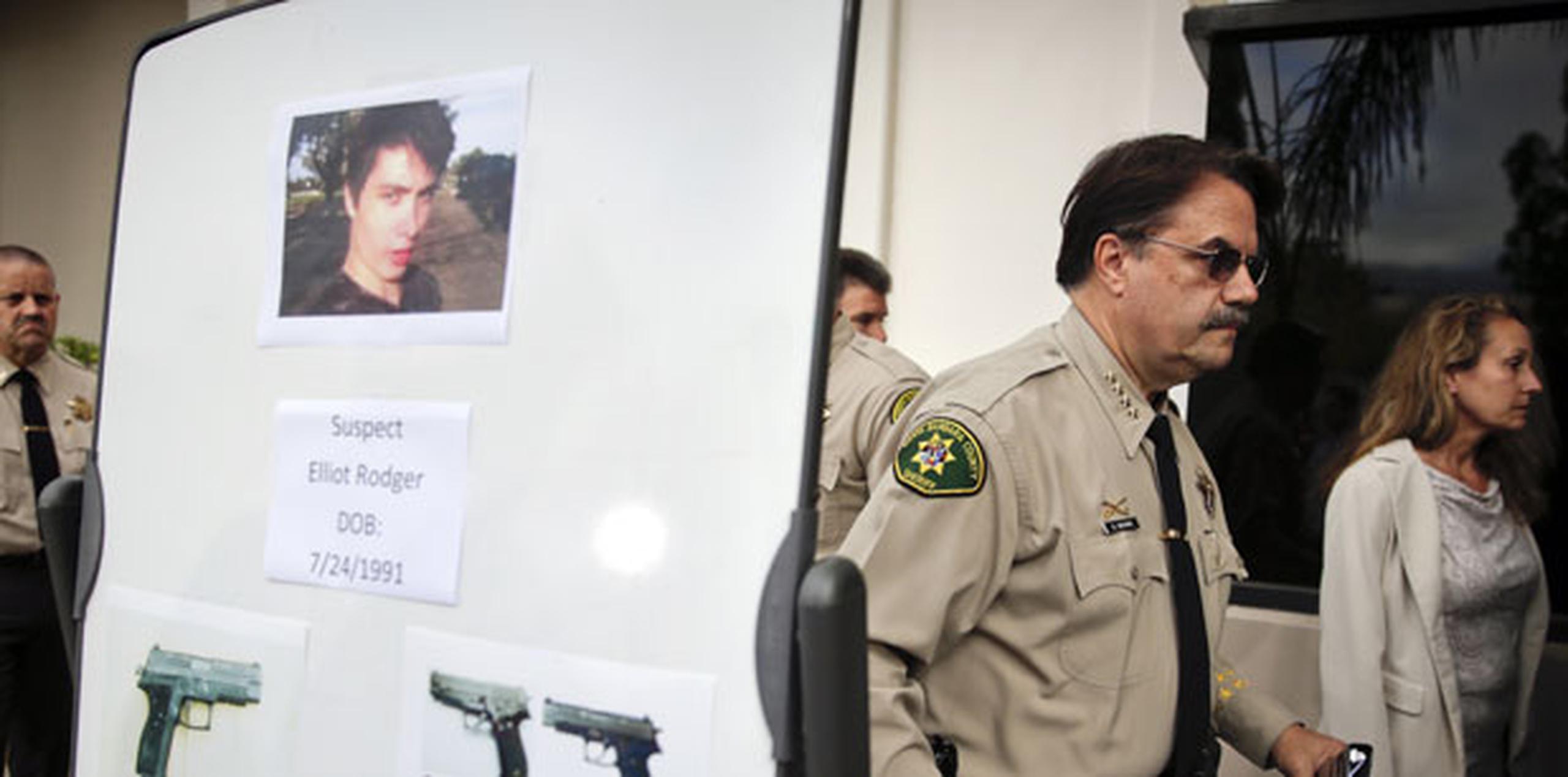 El jefe policial Bill Brown mientras le da la espalda a la foto del sospechoso. (AP)