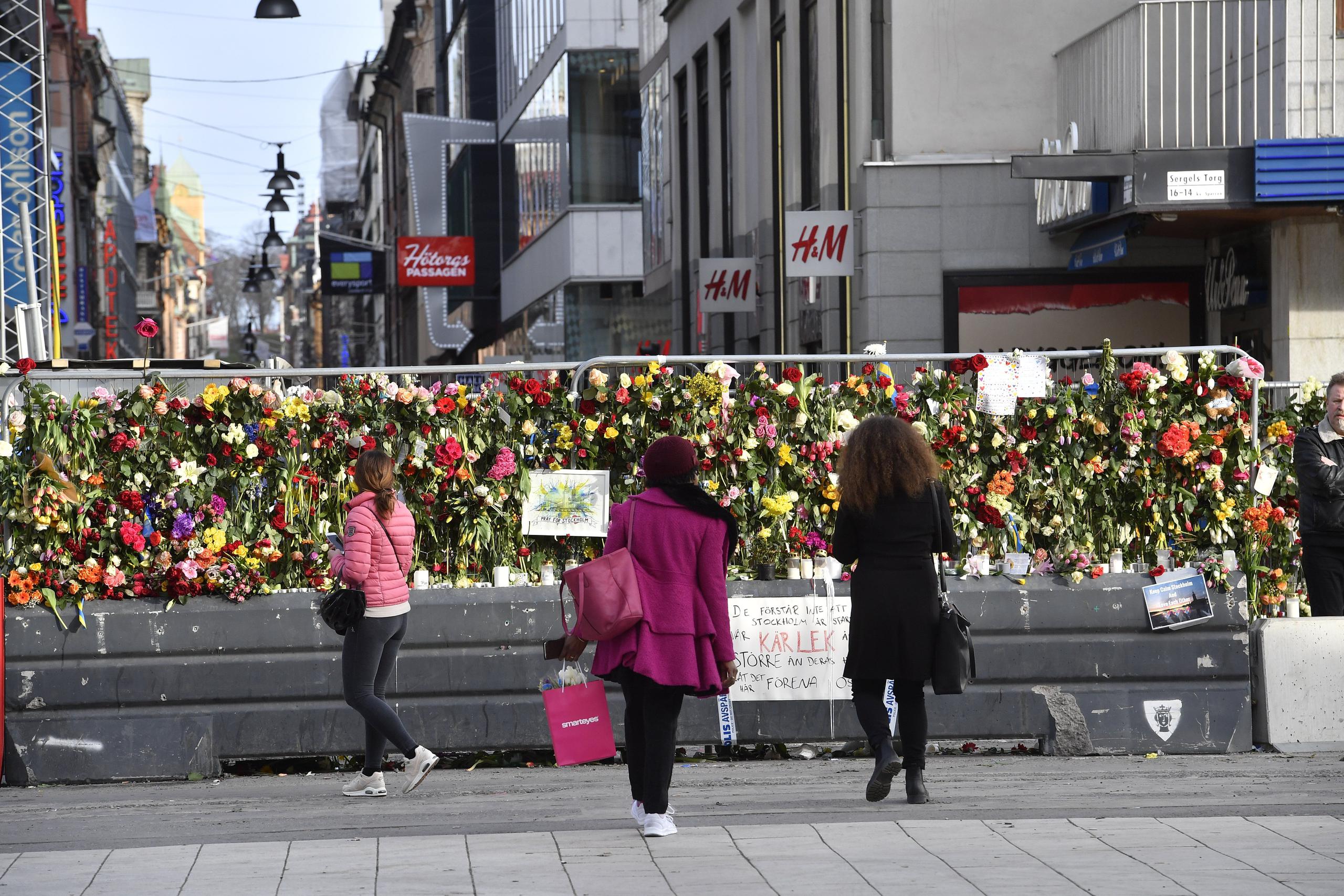 Miles de flores han sido depositadas en un monumento de recuerdo improvisado en una calle de Estocolomo cercana a la tienda. (AP)