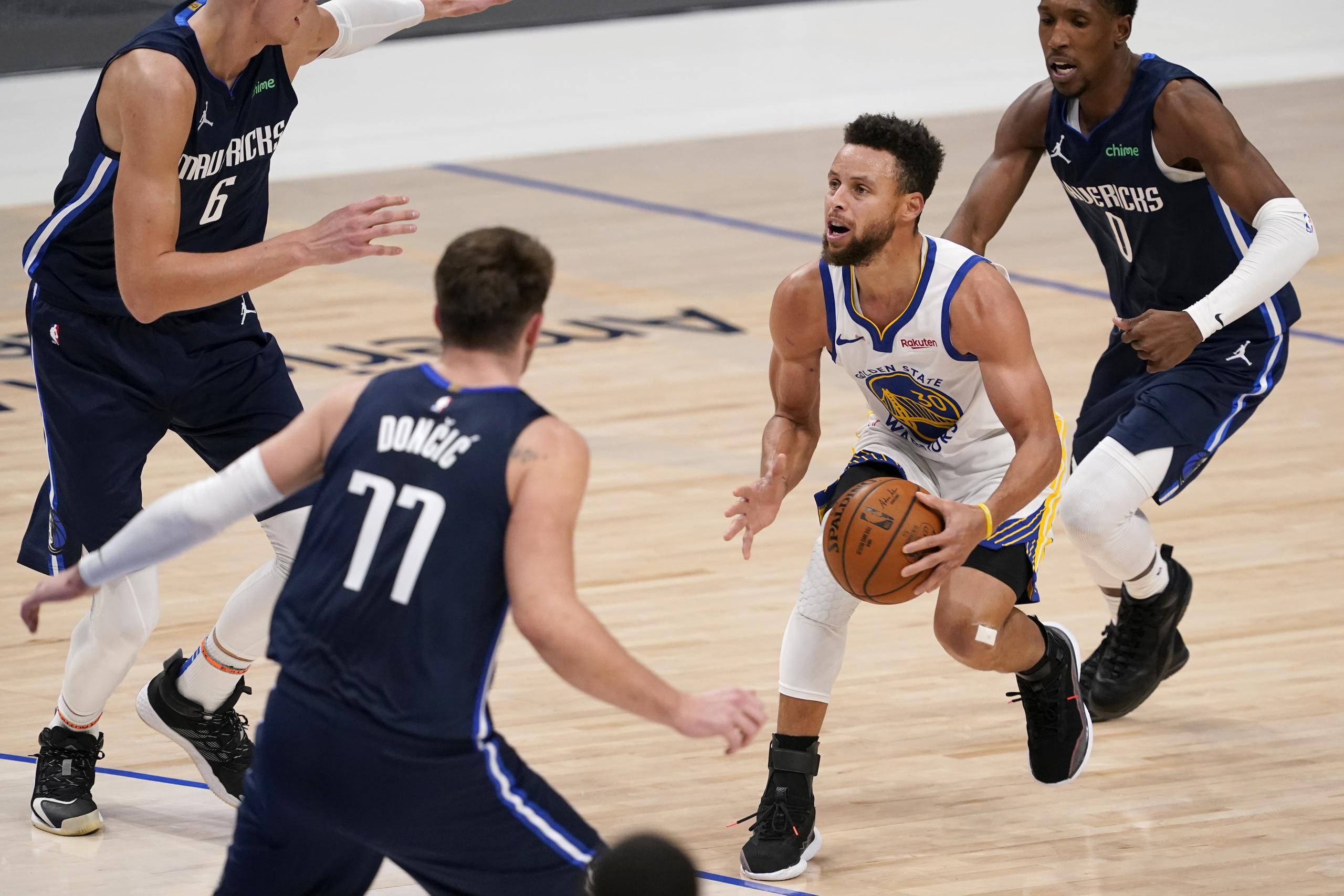 Stephen Curry, de los Warriors, se prepara para disparar un triple contra los Mavericks de Dallas.