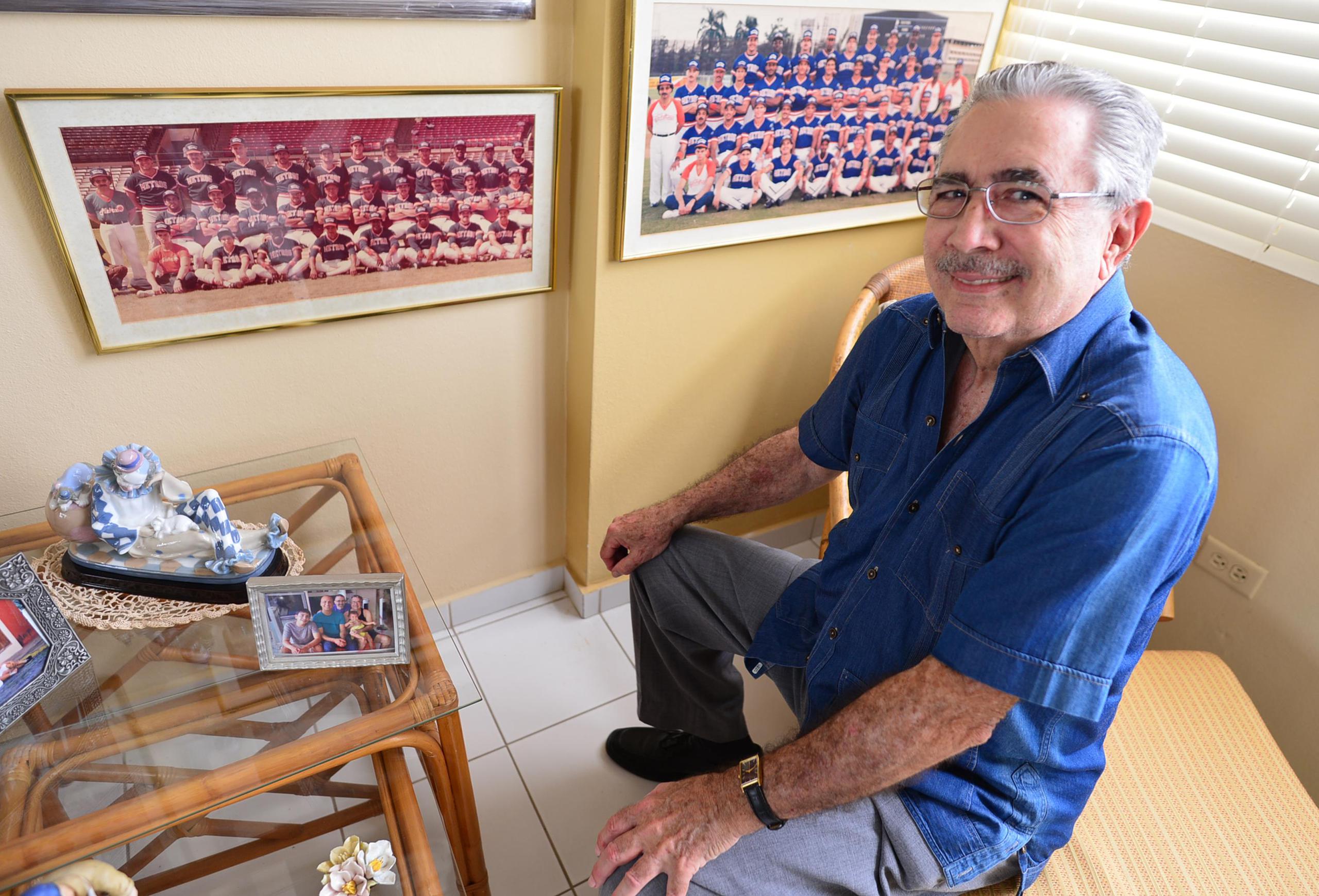 Ernesto Díaz González se convirtió de narrador del béisbol profesional en dueño de equipo a mediados de los 80. Aquí posa junto a fotos de las dos ediciones de los Metros de San Juan.