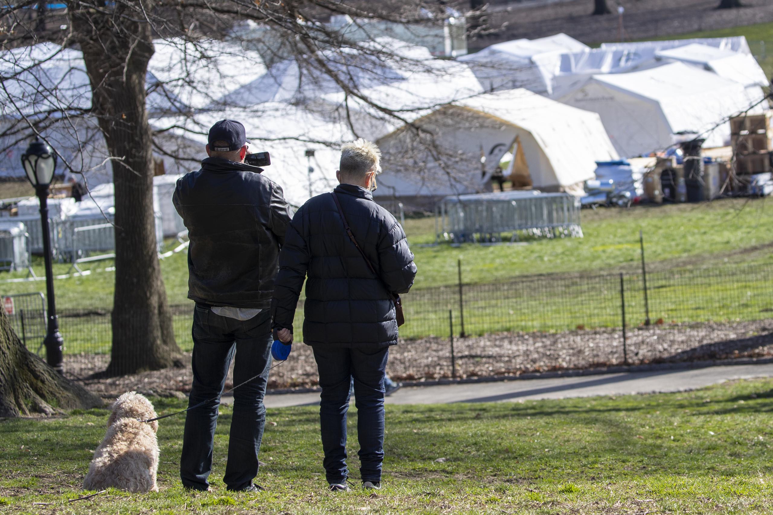 Una pareja se detiene a tomar una fotografía del hospital Samaritan's Purse mientras pasean a su perro por el Central Park de Nueva York