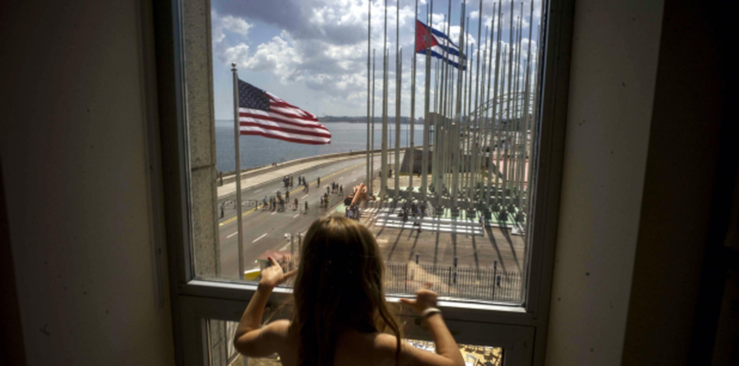 Una niña observa una ceremonia de izamiento de bandera desde la recién abierta embajada de Estados Unidos en La Habana. (AP)