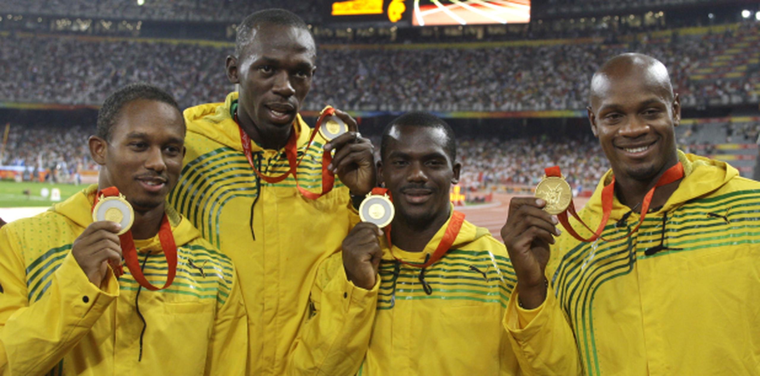 Nesta Carter (tercero desde la izquierda) arrojó positivo a un estimulante prohibido, por lo que toda la cuarteta de Jamaica ganadora del 4x100 en Beijing 2008 fue despojada del oro. (Archivo)