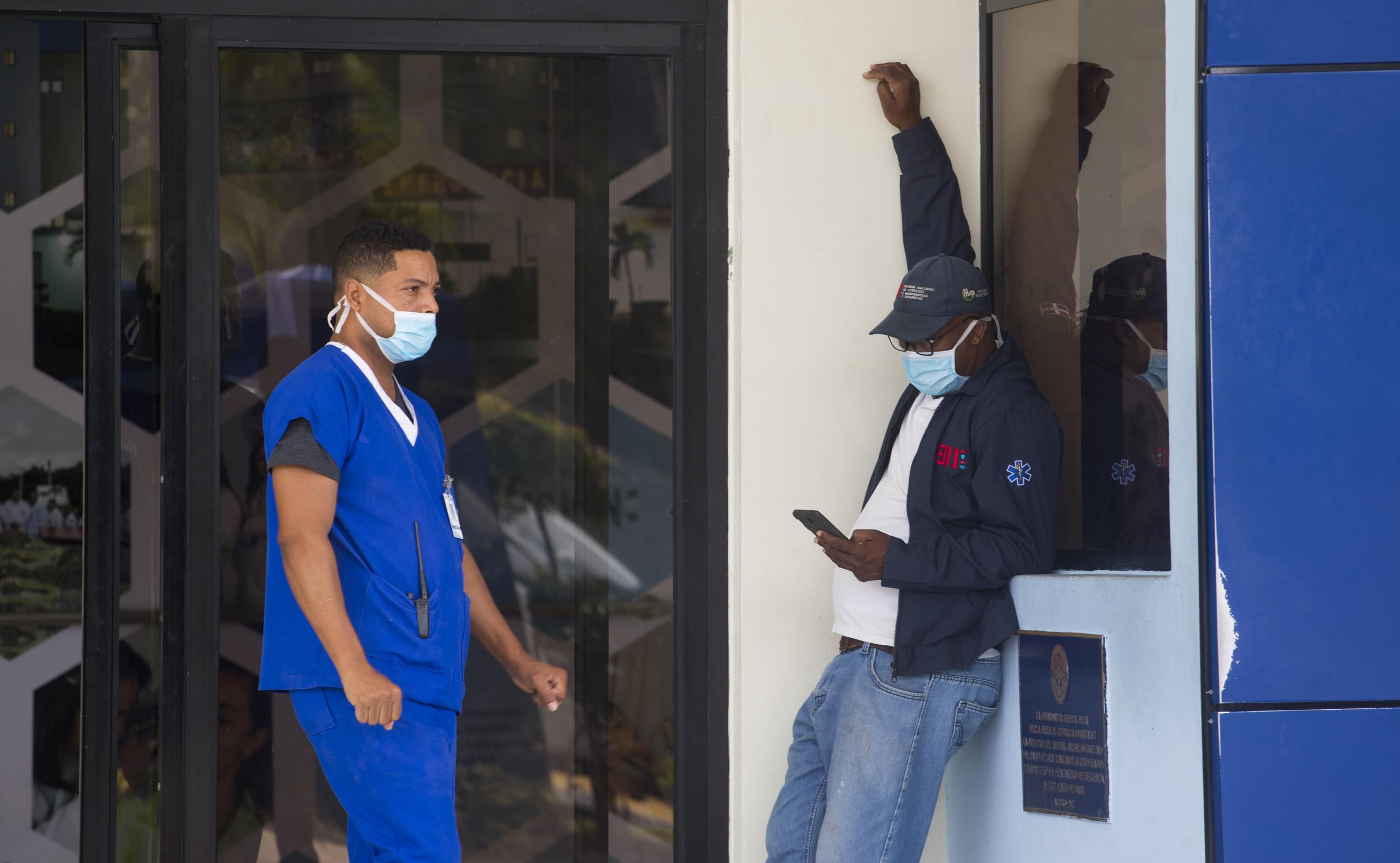Funcionarios cubiertos con una mascarilla permanecen afuera del hospital militar Ramón de Lara, el cual ha sido debidamente preparado para recibir posibles casos de personas con síntoma de coronavirus, en Santo Domingo
