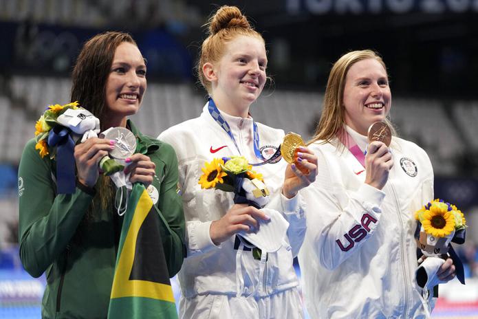 La medallista de oro Lydia Jacoby de los Estados Unidos, junto a la medallista de plata Tatjana Schoenmaker de Sudáfrica y la medallista de bronce Lilly King de los Estados Unidos, después de la final de los 100 metros braza femeninos el 27 de julio de 2021, en Tokio, Japón.