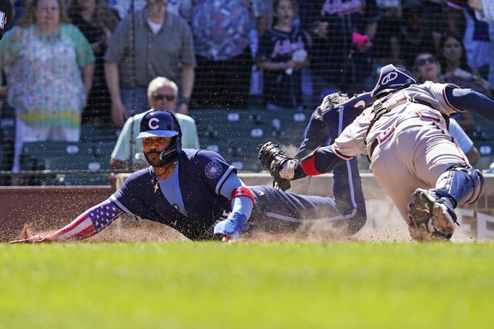 Jonathan Villar, de los Cubs de Chicago, se desliza a salvo en el plato ante el receptor de Atlanta, Travis d'Arnaud para marcar la única carrera de la victoria de los Cubs el viernes.