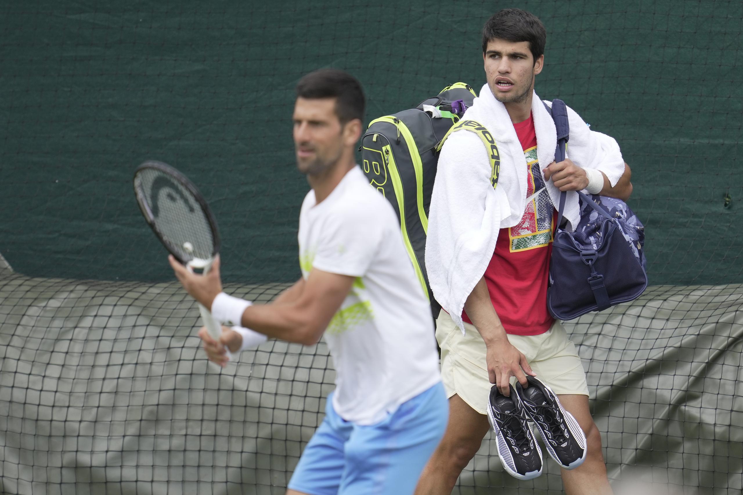 Novak Djokovic y Carlos Alcaraz durante un entrenamiento previo al torneo de Wimbledon, el domingo 2 de julio de 2023. (AP Foto/Kin Cheung)