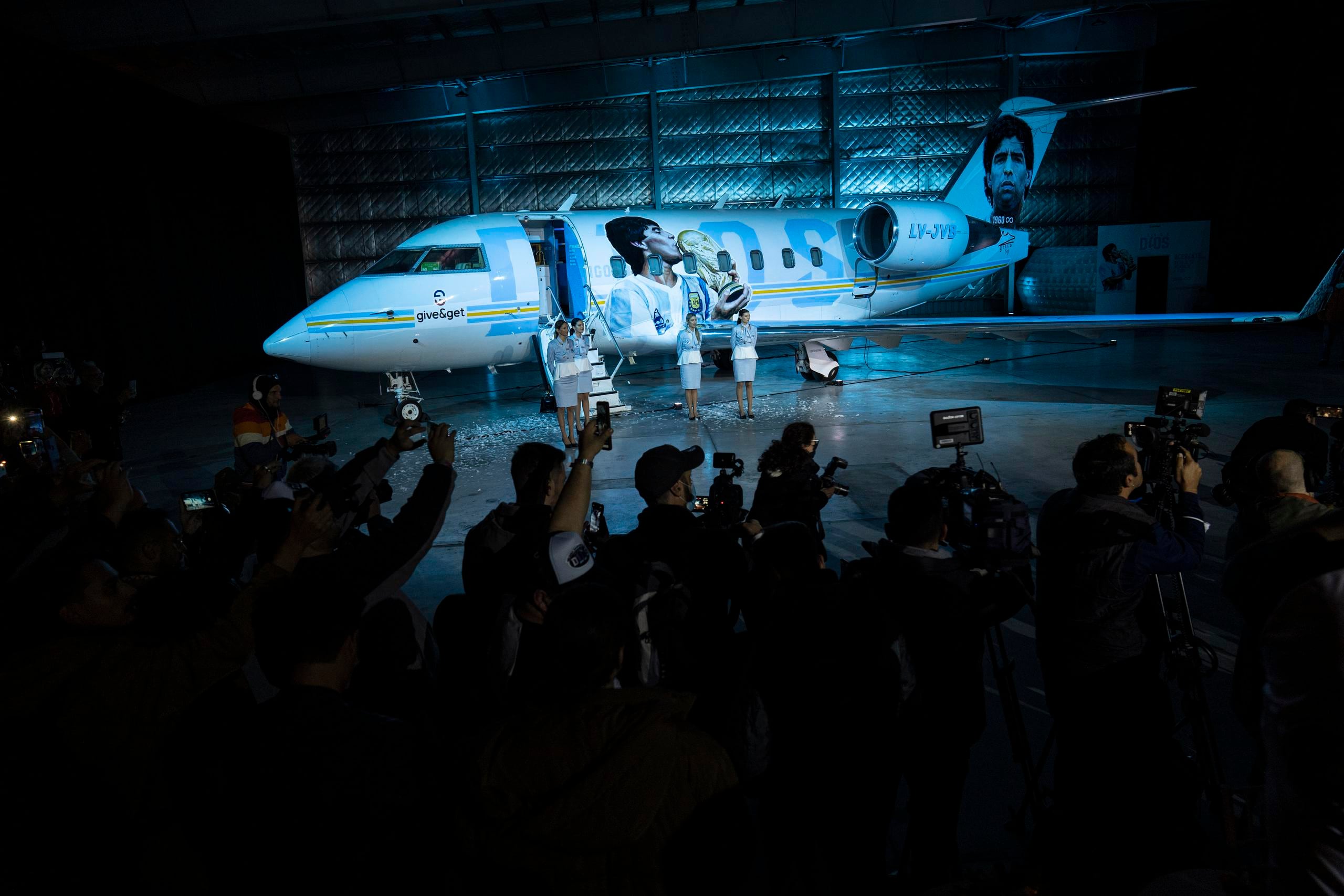 Un grupo de periodistas se congrega para la presentación de un avión dedicado al fallecido astro del fútbol Diego Maradona.