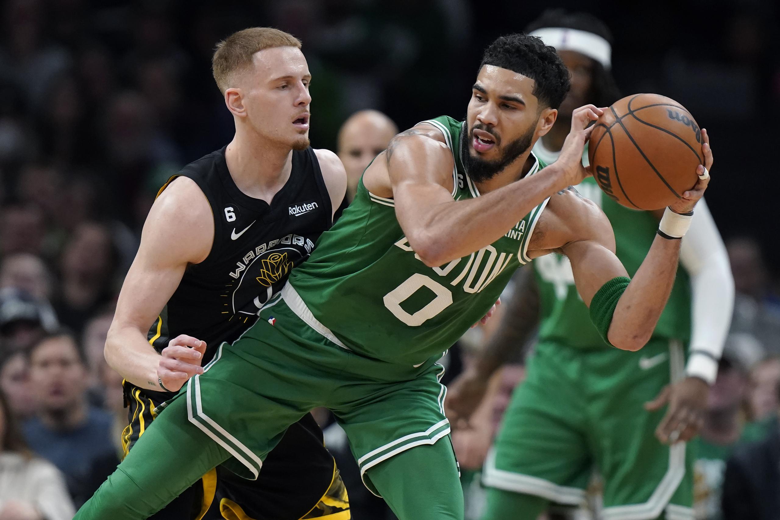 Jayson Tatum, de los Celtics de Boston, controla el balón frente a Donte DiVincenzo, de los Warriors de Golden State, durante el desafío del jueves.