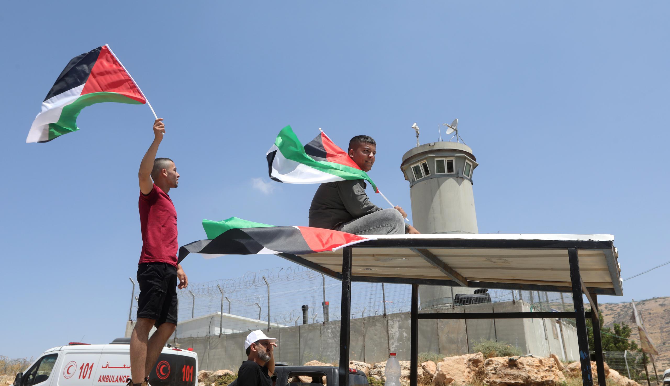 Palestinos protestan ondeando una bandera cerca del control israelí de Tayasee, en una imagen de archivo. (EFE/EPA/ALAA BADARNEH)