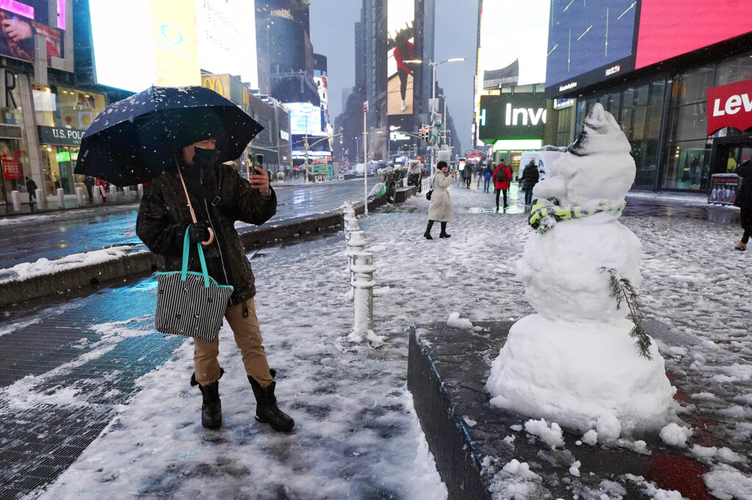Un hombre toma una foto de un muñeco de nieve en Times Square el 7 de enero de 2022.