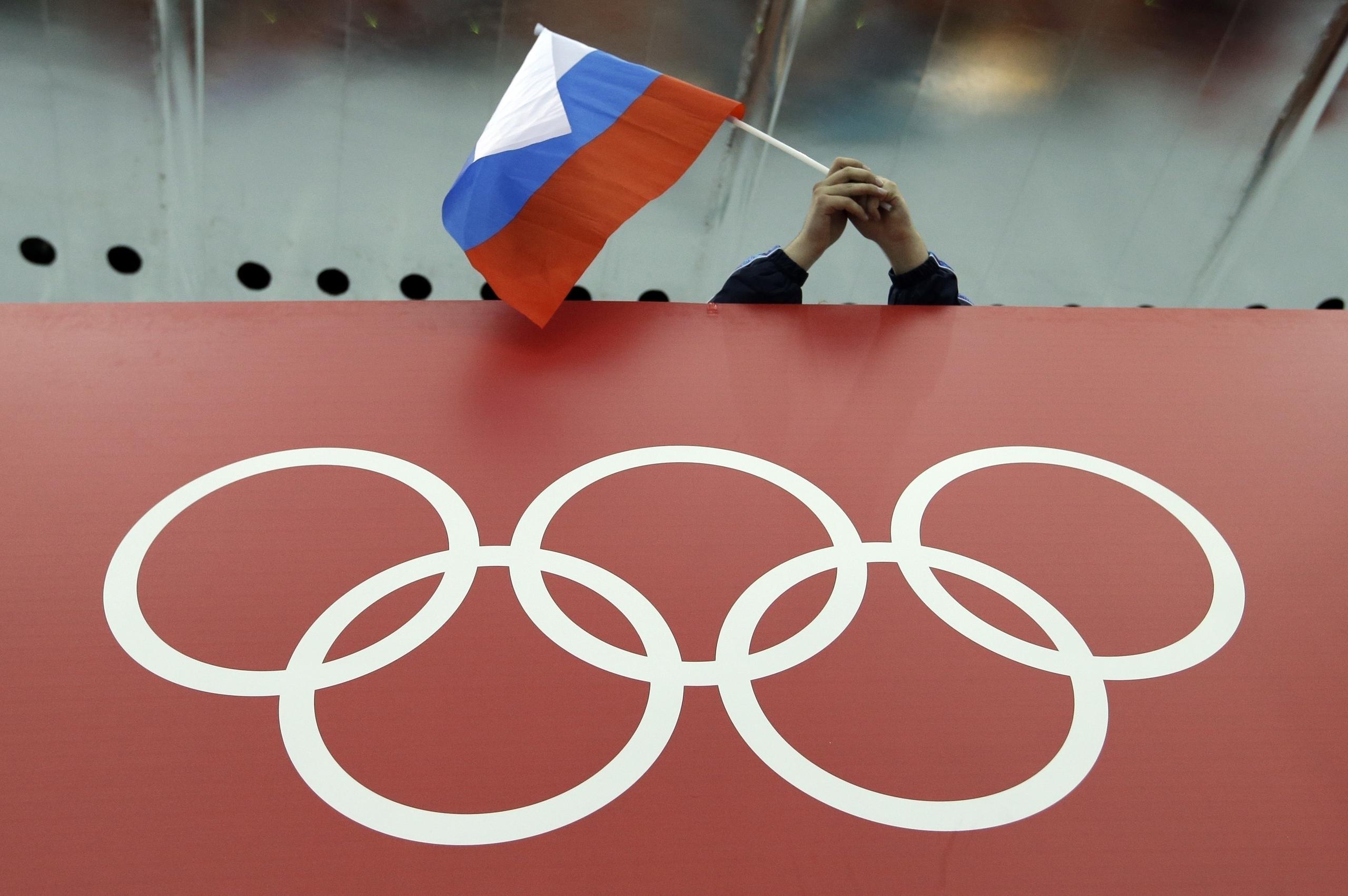 Una bandera rusa es desplegada encima de los anillos olímpicos durante los Juegos de Invierno en Sochi, Rusia.