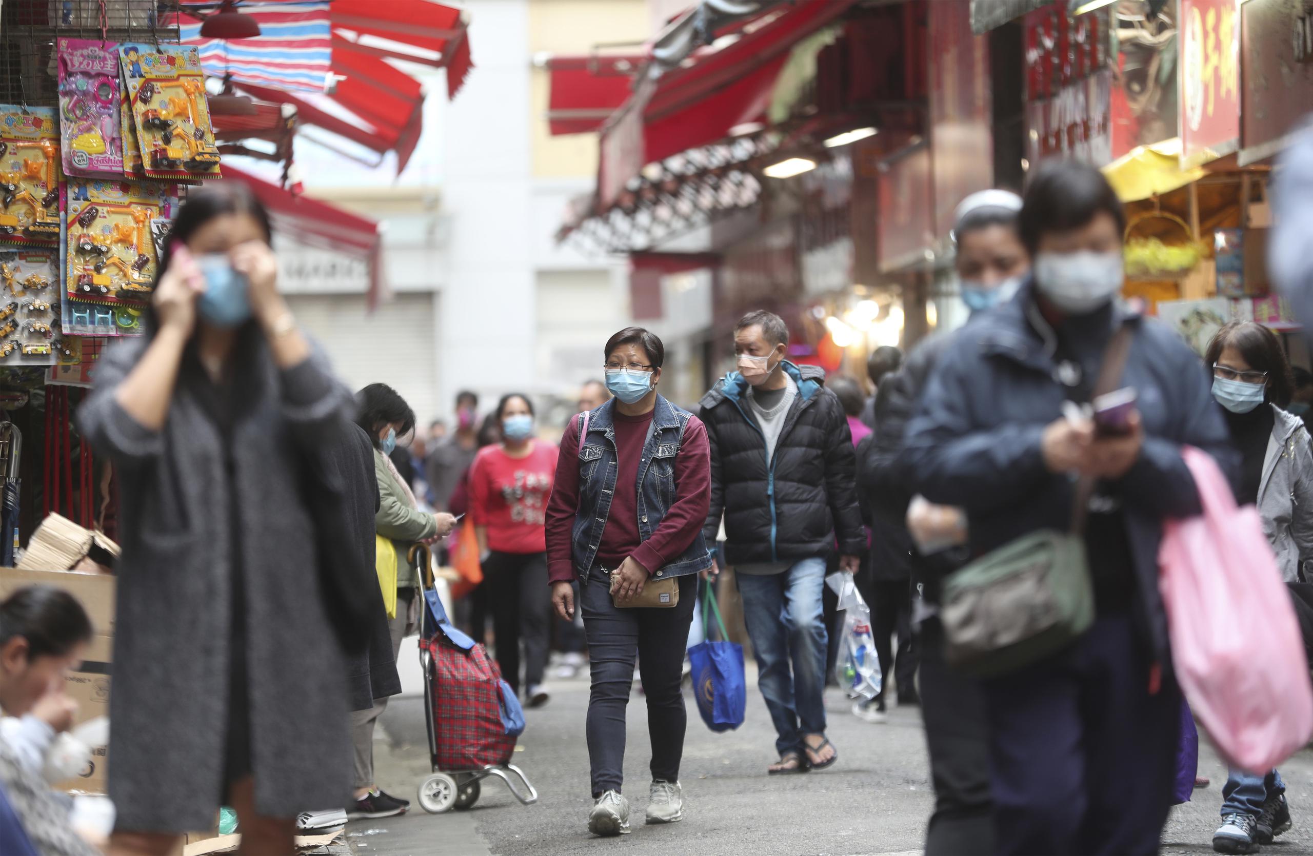 Personas con máscaras por el coronavirus en un mercado en Hong Kong.