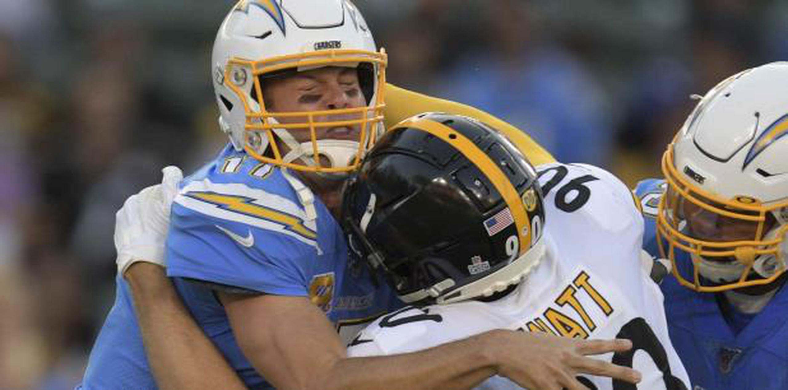 El quarterback de los Chargers de Los Ángeles Philip Rivers, recibe un golpe del linebaker de los Steelers de Pittsburgh T.J. Watt durante un partido el pasado fin de semana. (AP / Kyusung Gong)