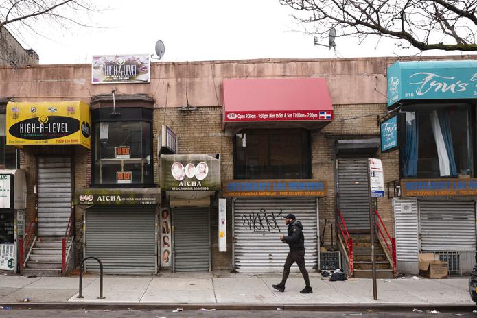 Fotografía de archivo del 8 de abril de 2020 de un peatón caminando frente a pequeños negocios que debieron cerrar sus puertas por la pandemia de coronavirus en el barrio Crown Heights de Brooklyn, en Nueva York.