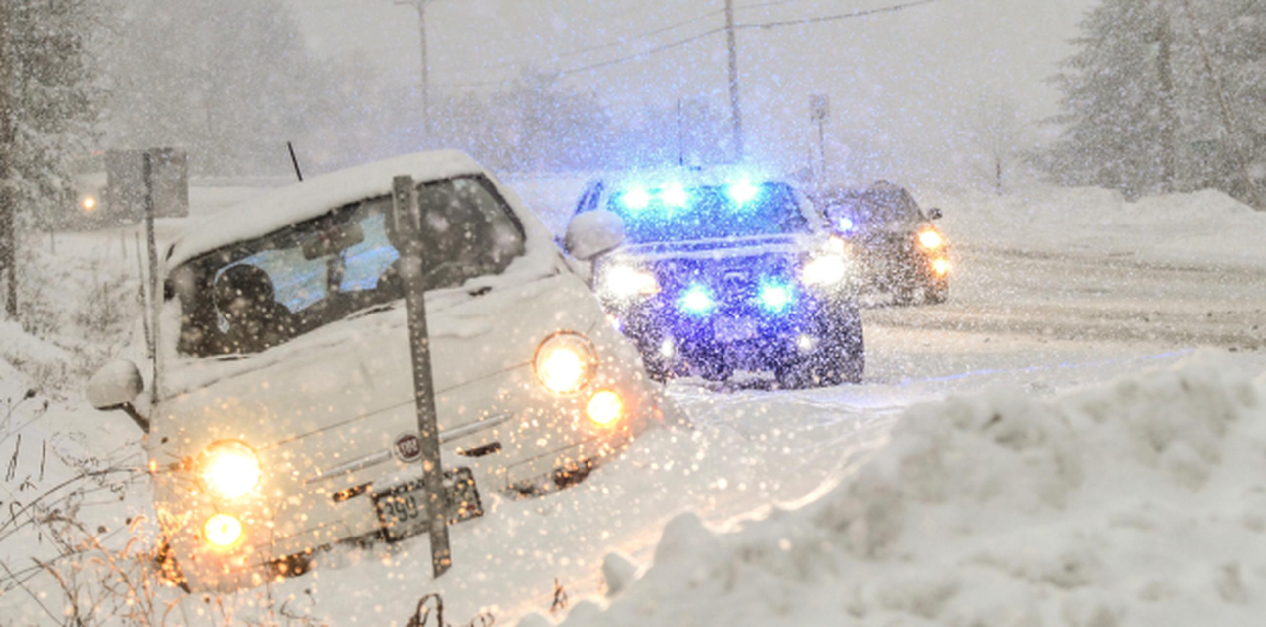 Policías socorren a conductor que se deslizó fuera de la carretera durante la tormenta invernal en Chesterfield, New Hampshire. (AP)