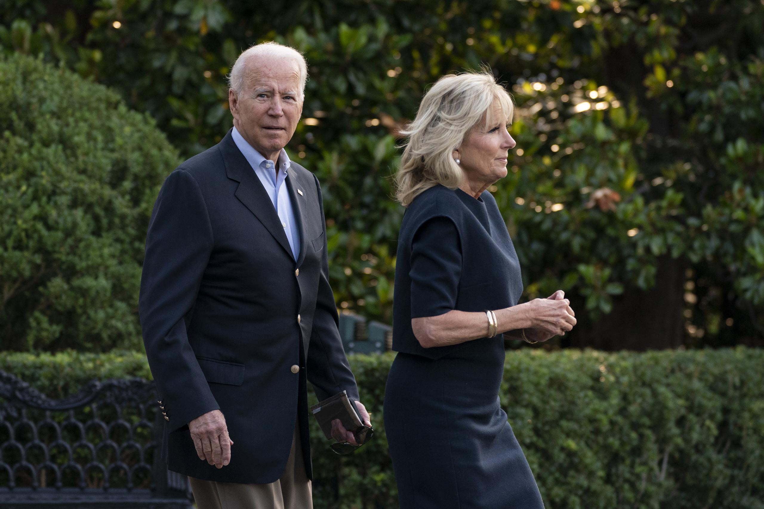El presidente estadounidense Joe Biden y la primera dama Jill Biden cruzan el jardín de la Casa Blanca.