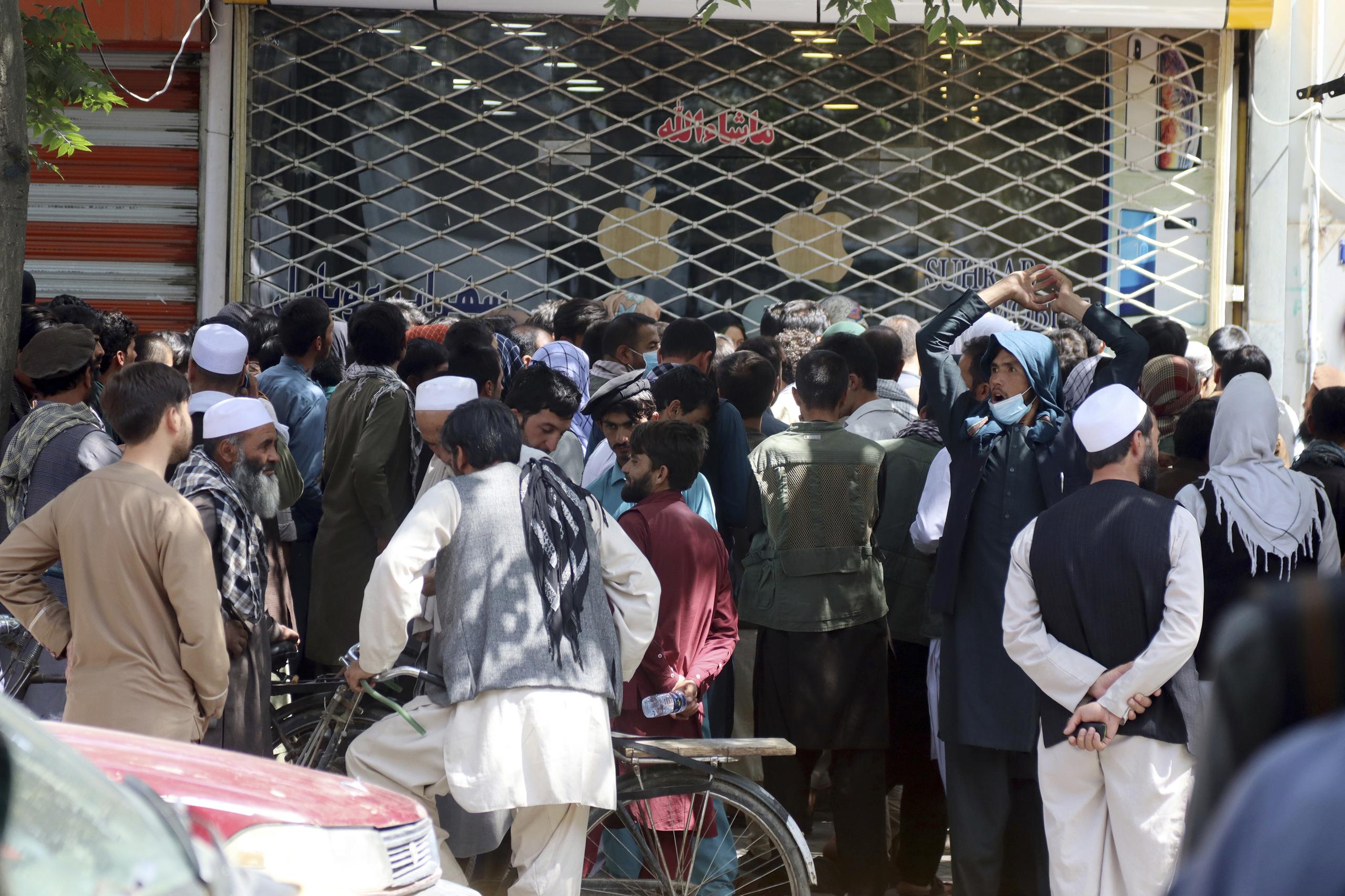 Afganos esperan durante horas para retirar dinero ante el Banco de Kabul, en Kabul, Afganistán, el 28 de agosto de 2021.