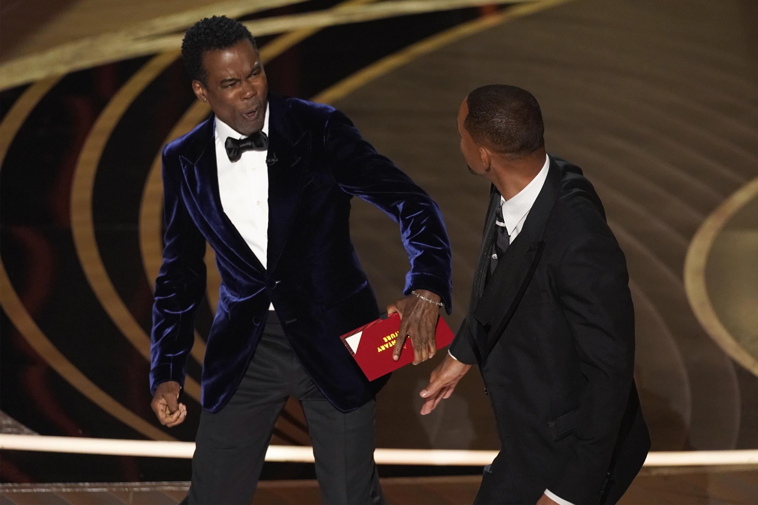 El momento que Chris Rock reacciona a la bofetada de Will Smith en pleno escenario durante la entrega de los premios Oscar el 27 de marzo de 2022 en el Teatro Dolby, en Los Ángeles.