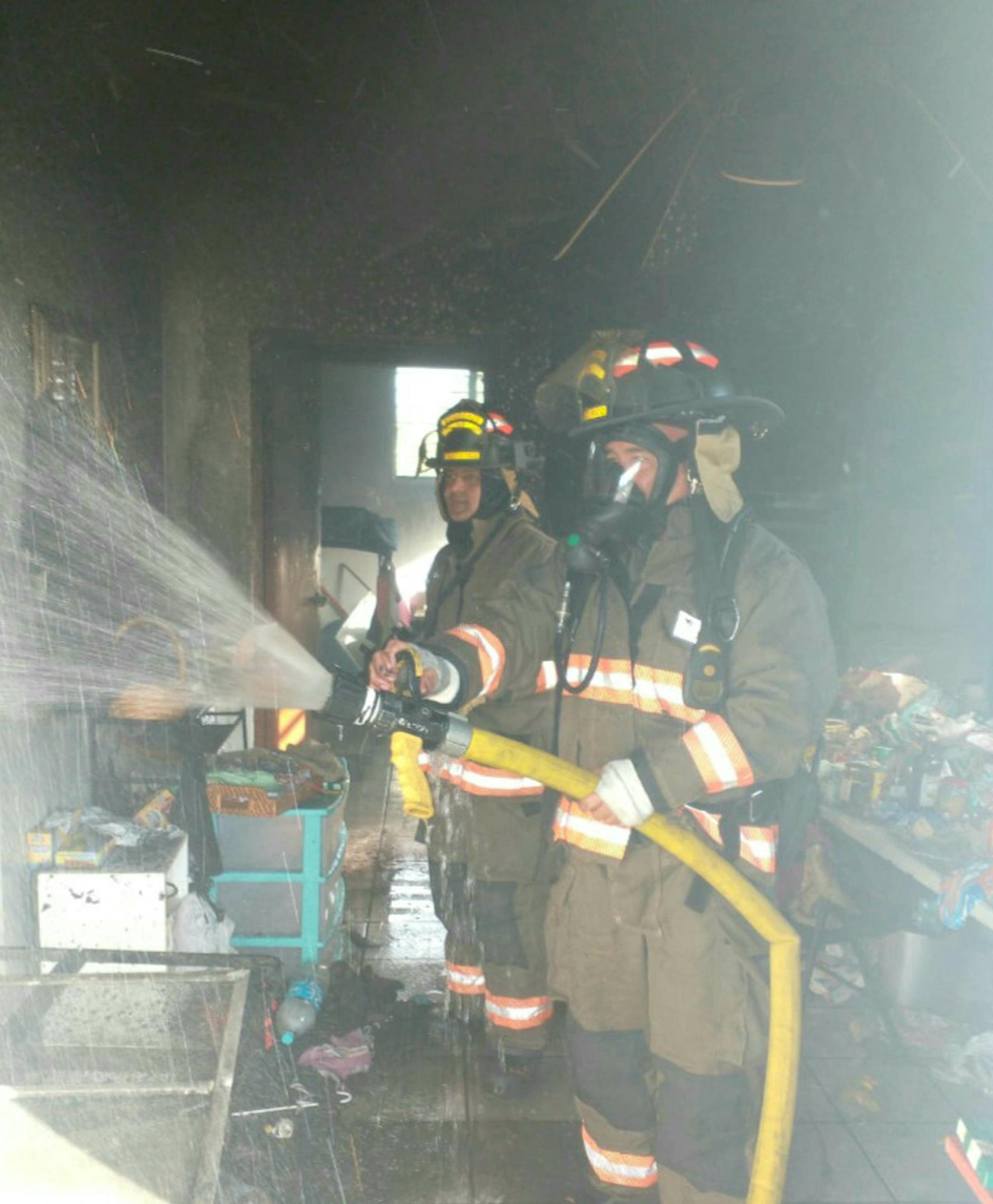 Bomberos extinguen un fuego ocasionado por una vela encendida en una residencia del barrio Hato Arriba, en Arecibo.