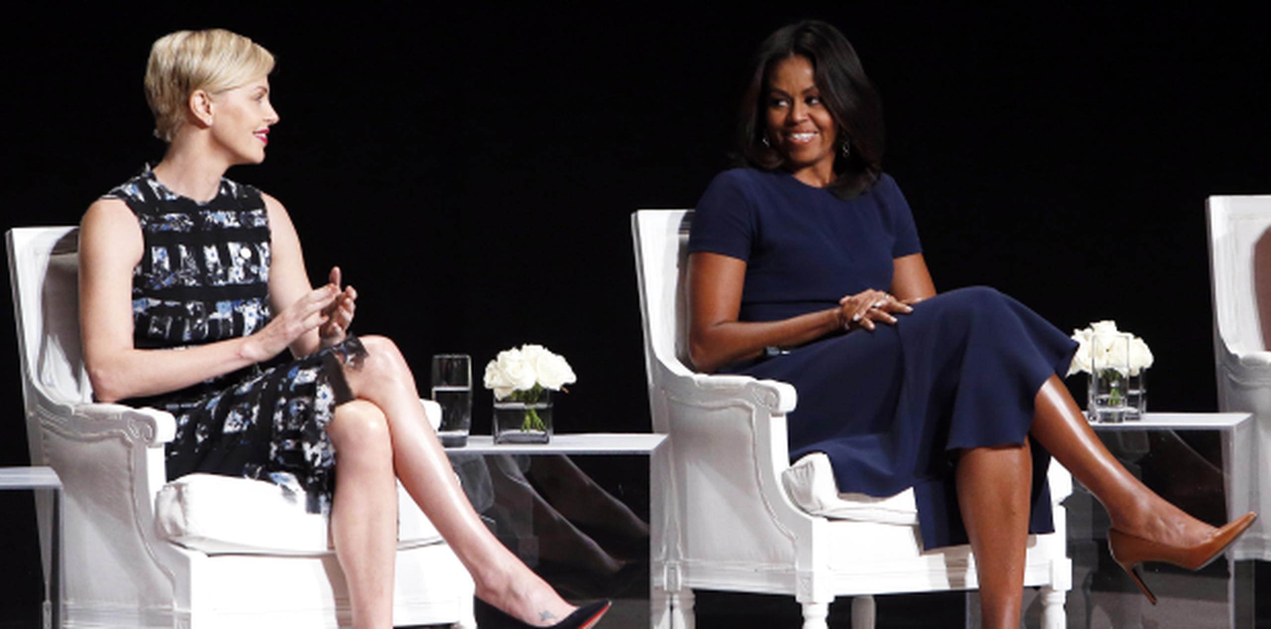 Charlize Theron y Michelle Obama compartieron en el Teatro Apollo exhortando a las niñas a no ponerse trabas. (AP)
