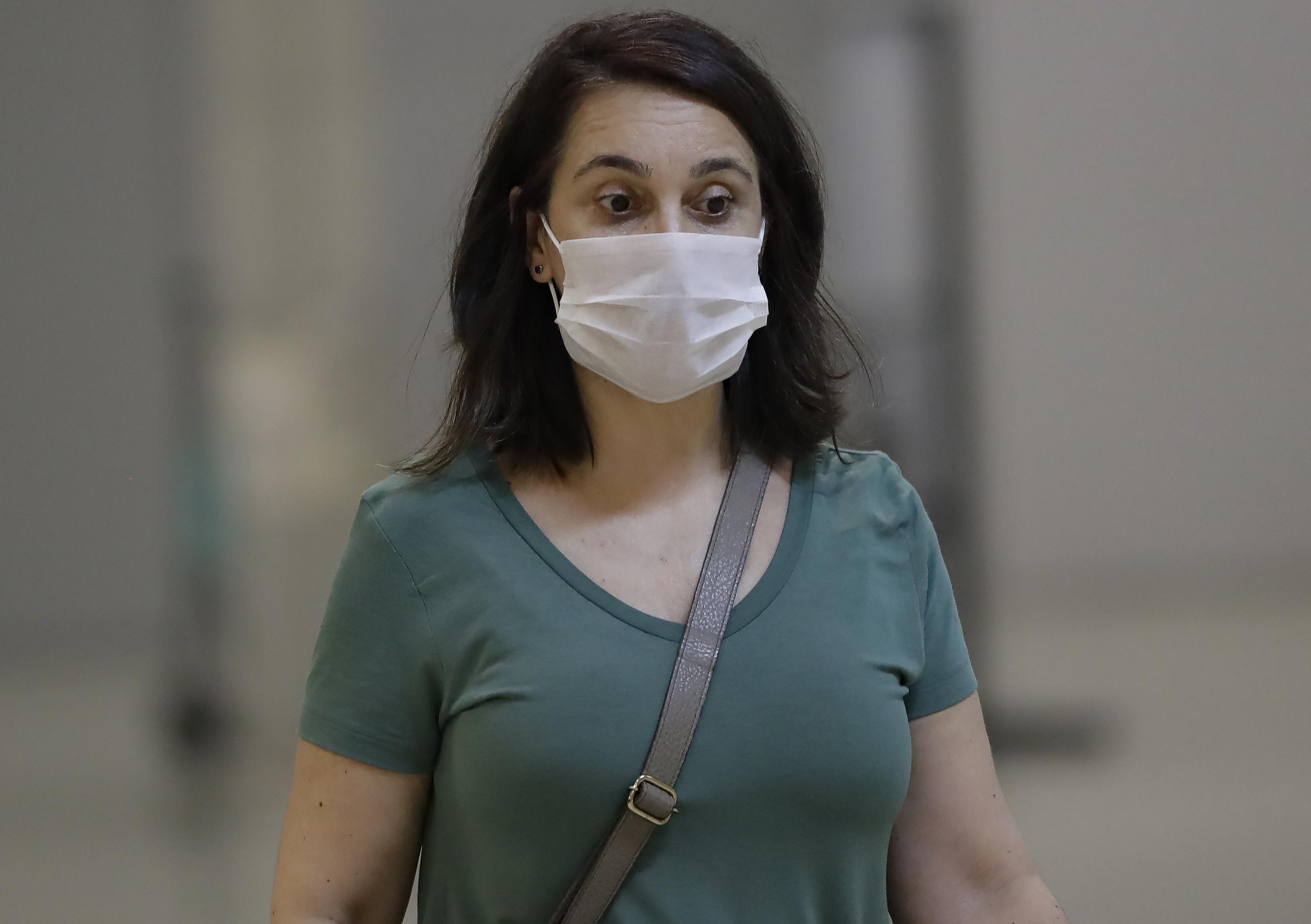 Una pasajera que usa una máscara como precaución contra la propagación del nuevo coronavirus COVID-19 llega al Aeropuerto Internacional de Sao Paulo en Brasil.