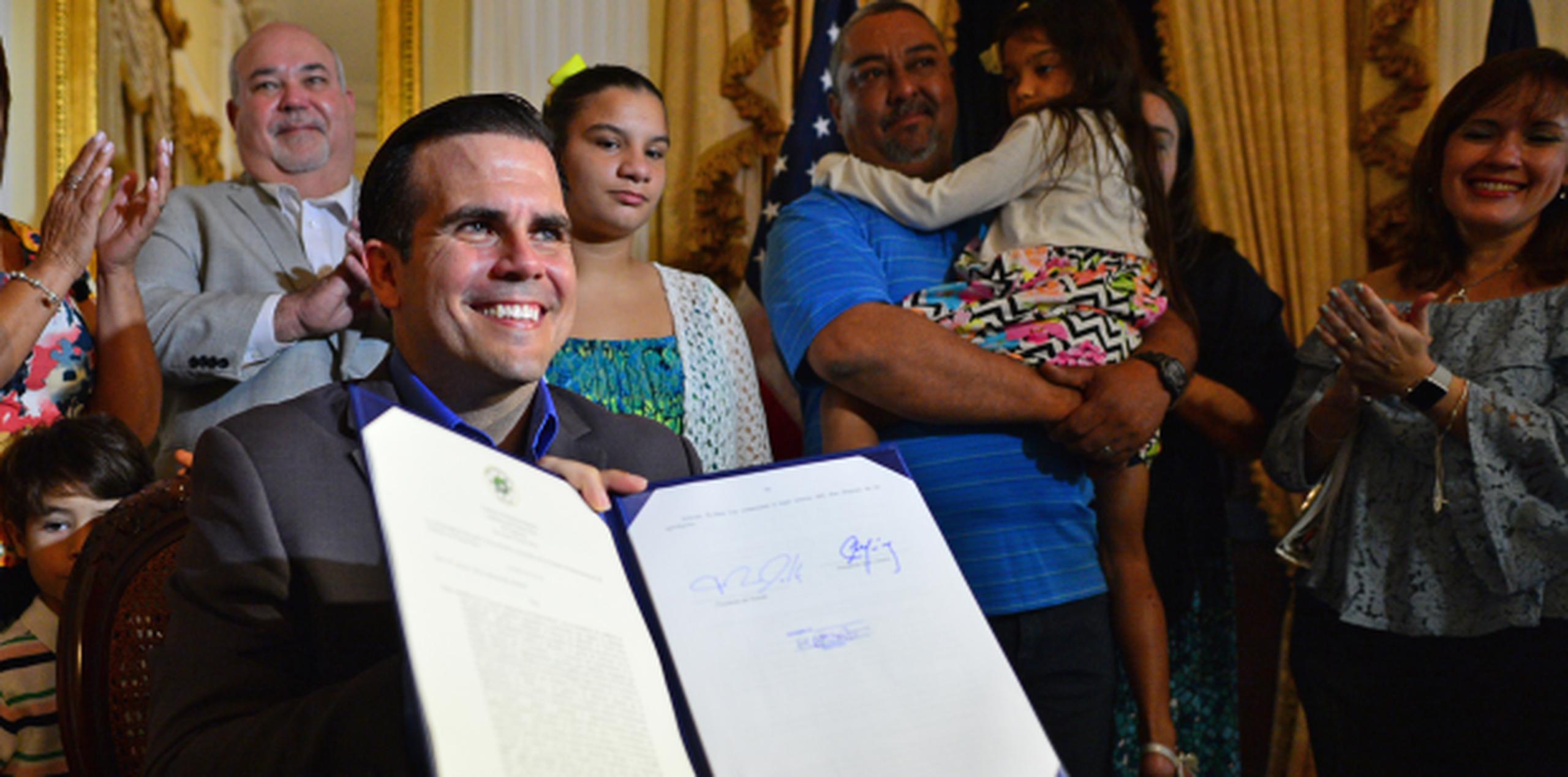 Rosselló sonríe tras estampar la firma en la nueva ley de adopción. (LUIS.ALCALADELOLMO@GFRMEDIA.COM)