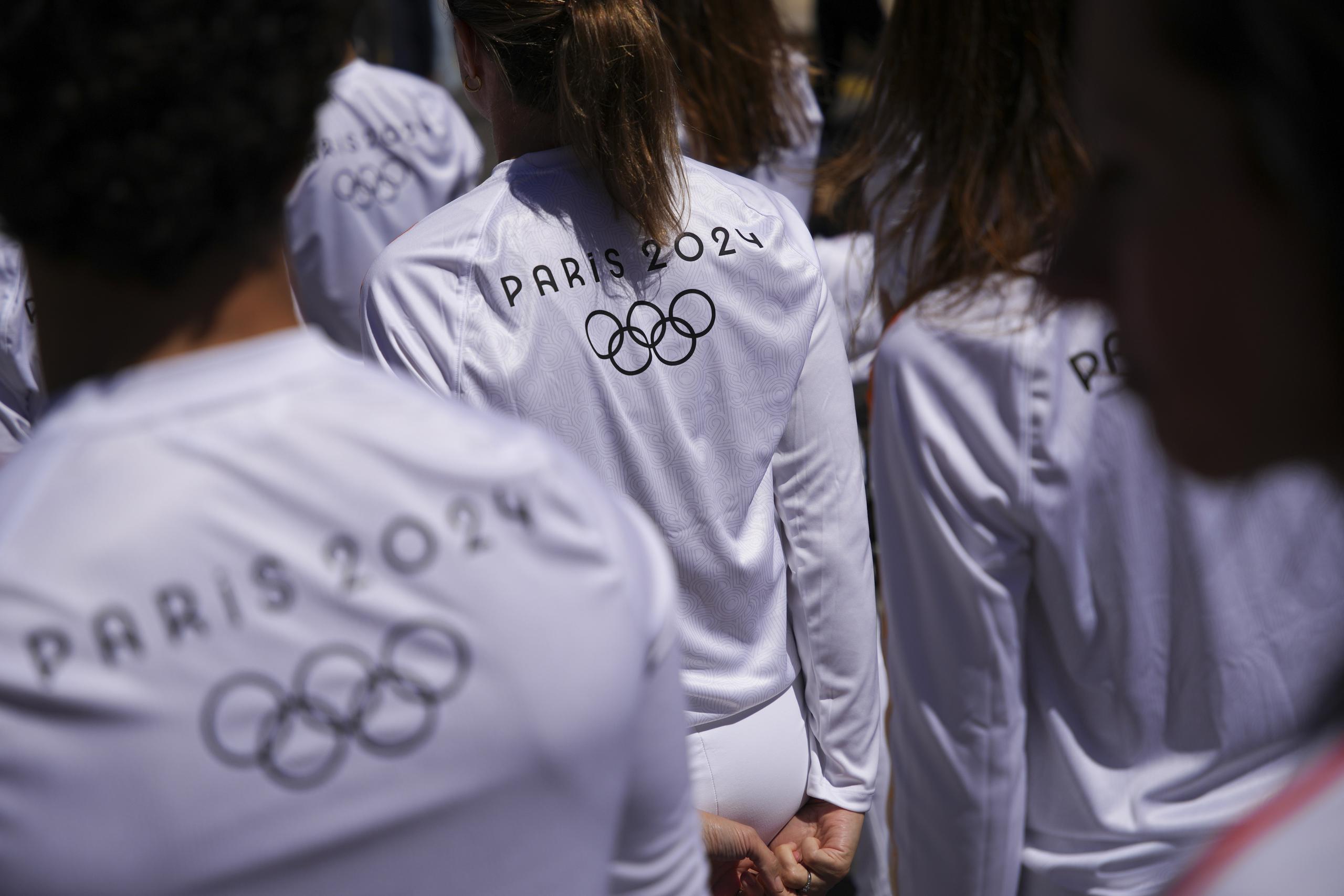 Un grupo de personas que serían parte del relevo de la antorcha esperan su turno para transportar por un momento el fuego olímpico.