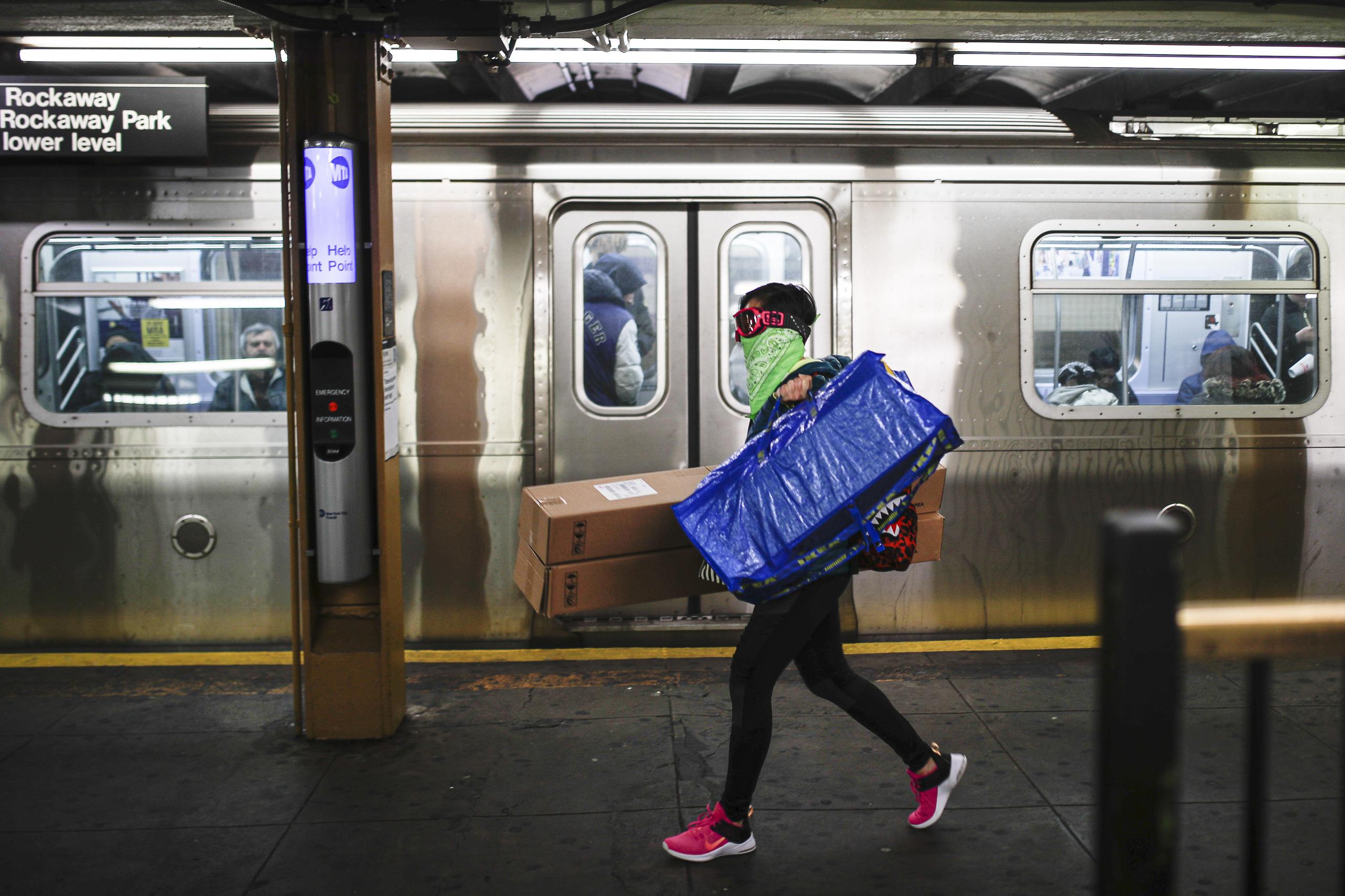 A fin de protegerse contra el coronavirus, una persona se cubre la cara con unas gafas y un paliacate dentro del metro de la Ciudad de Nueva York