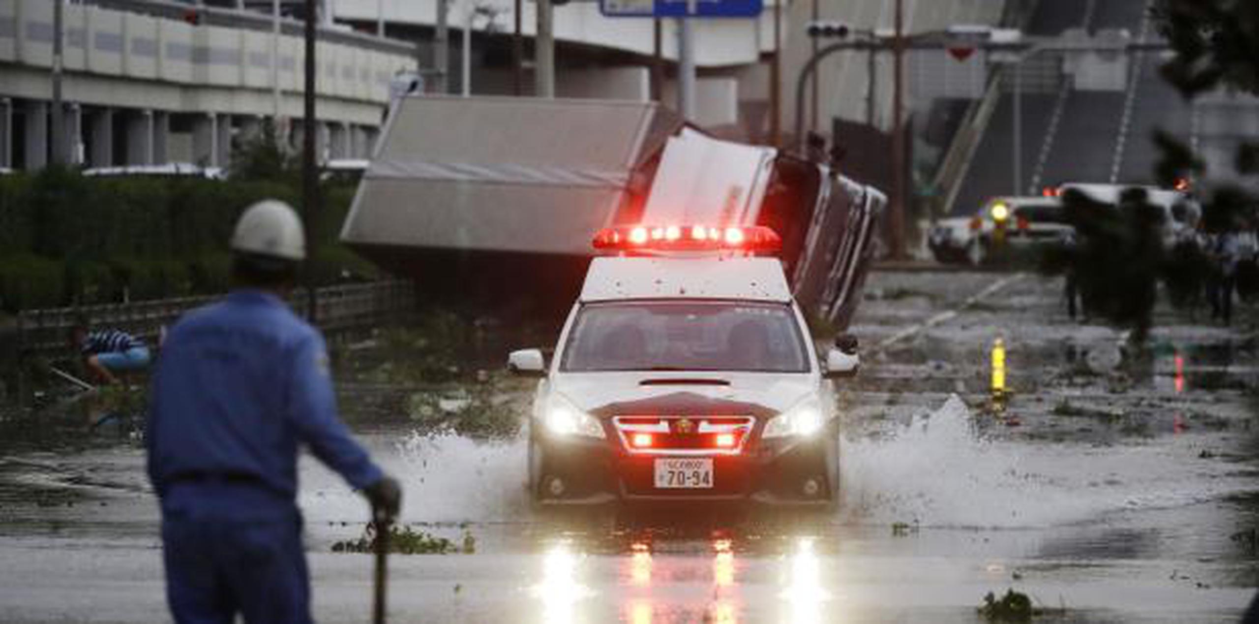Un coche de policía avanza por una carretera inundada tras el paso del tifón Jebi por Osaka, al oeste de Japón. (Kota Endo/Kyodo News vía AP)