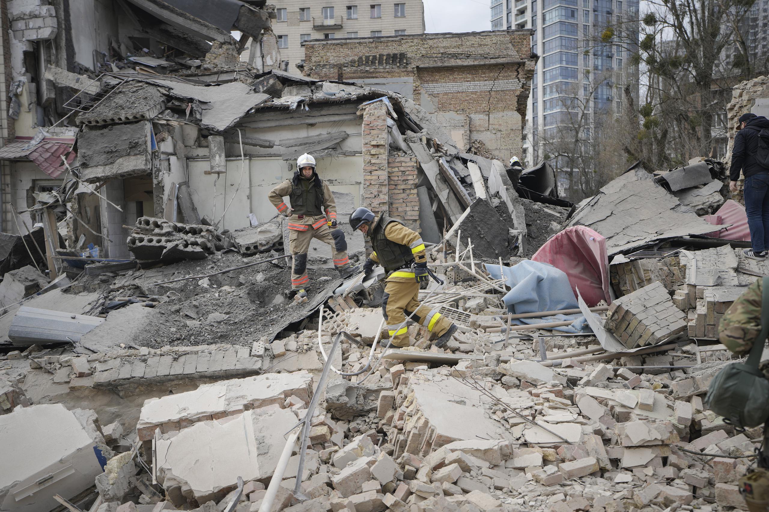 Trabajadores de emergencias inspeccionan los daños tras un ataque aéreo en Kiev, Ucrania, el lunes 25 de marzo de 2024. Cinco personas resultaron heridas en el ataque contra el distrito de Pechersk de Kiev, dos de las cuales fueron hospitalizadas. (AP Foto/Vadim Ghirda)