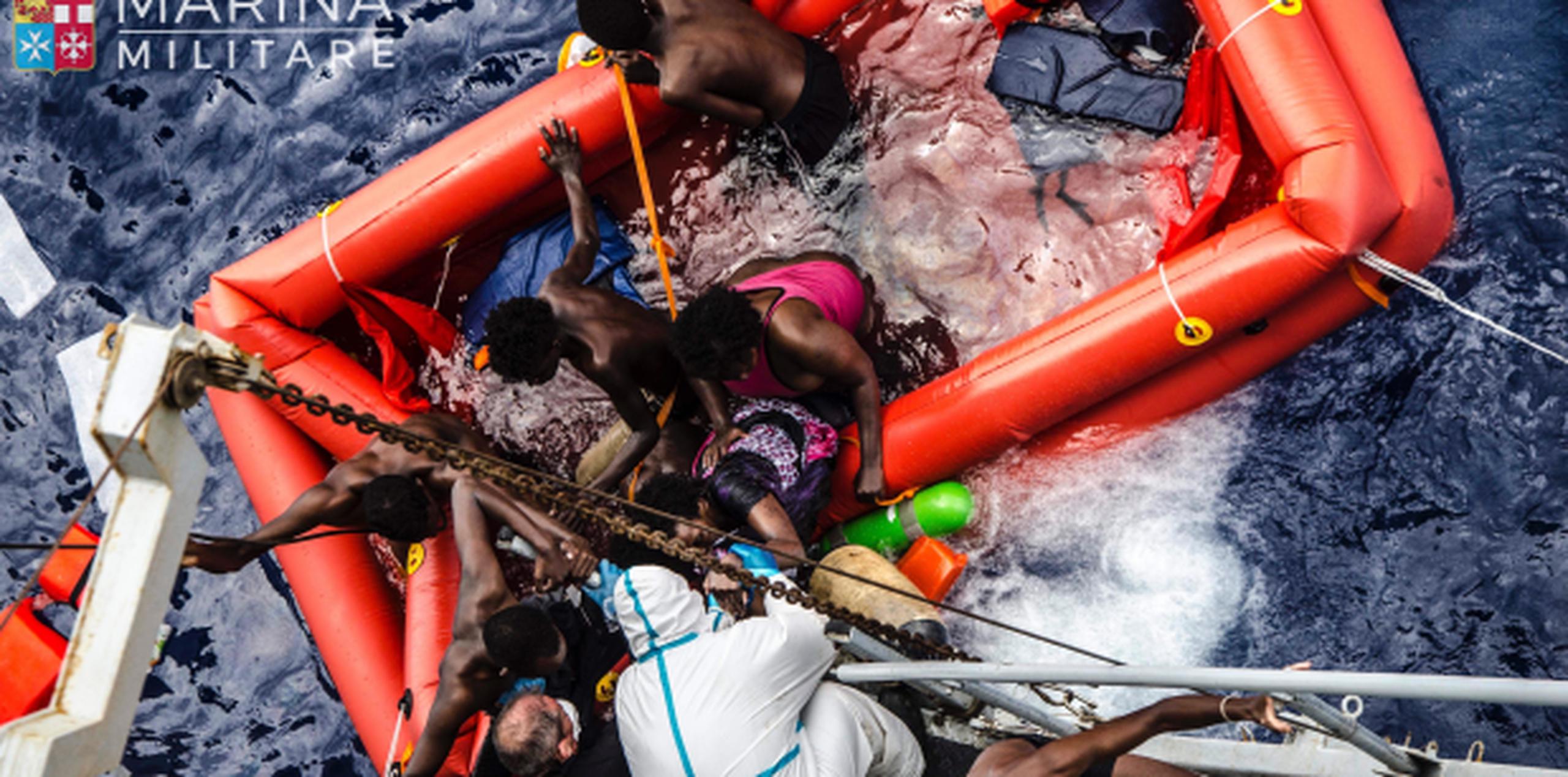 Rescatistas ayudan a varios migrantes a abordar un navío de la Marina Italiana luego que el bote en que intentaban llegar a Europa naufragara frente a las costas de Libia. (Raffaele Martino/Marina Militare via AP Photo)
