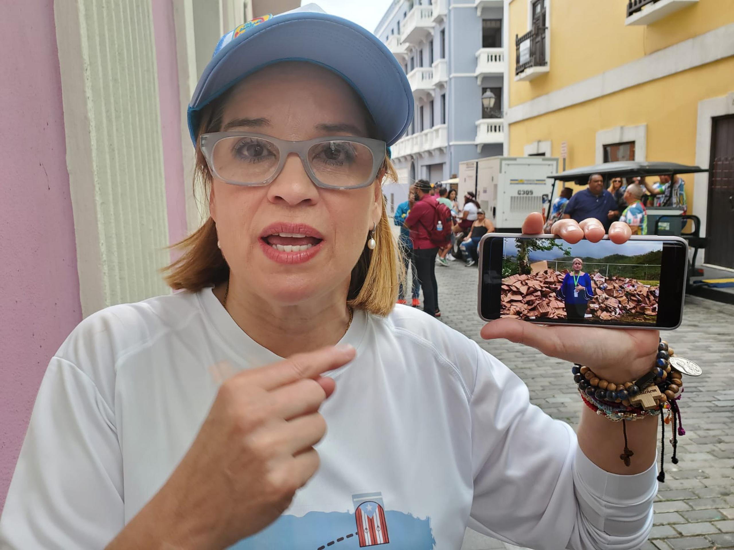 Carmen Yulín Cruz Soto muestra en su celular una imagen de la gobernadora Wanda Vázquez.