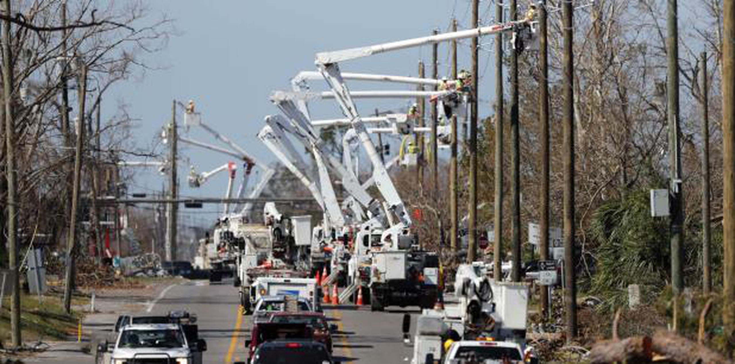 Trabajadores de servicio eléctrico instalando postes y cables nuevos en Panama City, Florida, el jueves pasado. (AP / Gerald Herbert)