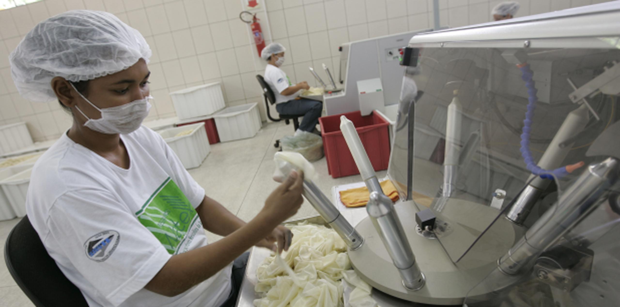 Un empleado verifica la goma de los condones en una fábrica en Brasil. (Prensa Asociada)