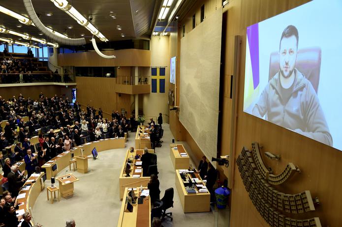 El presidente ucraniano, Volodimr Zelenski (en la pantalla) en su intervención por videoconferencia ante el Parlamento sueco. EFE/EPA/PAUL WENNERHOLM
