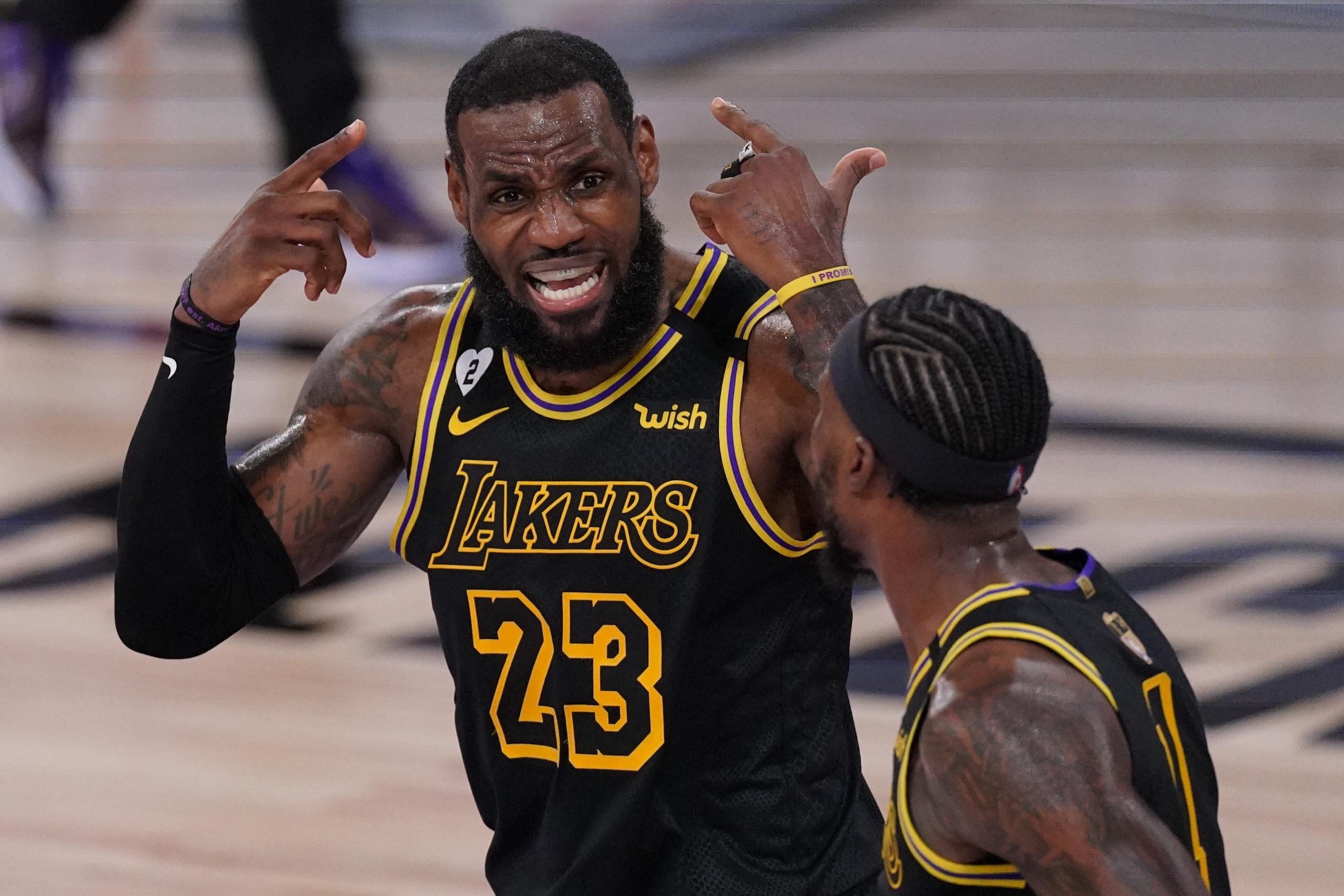 LeBron James habla con su compañero Kentavious Caldwell-Pope durante la primera mitad del quinto juego de la Finales entre Lakers y el Heat.