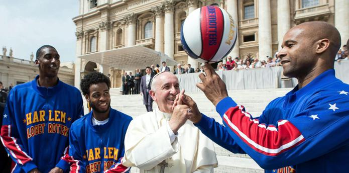 El jugador Flight Time agarró una pelota  y la hizo girar sobre un dedo, y luego tomó el índice derecho del papa y dejó que el pontífice intentara el truco. (EFE)