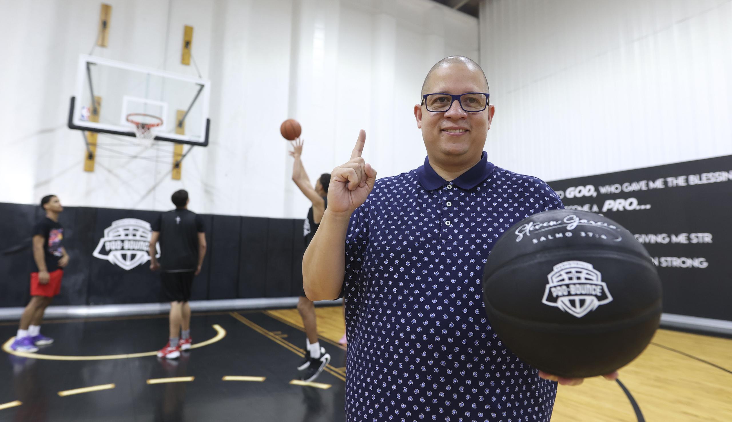 Héctor Delgado posa con un balón en el centro de entrenamiento de baloncesto ProBounce Academy en Carolina, donde los jóvenes que reclute para jugar baloncesto en la Jireh Basketball Academy entrenarán para pulir sus destrezas en el deporte.