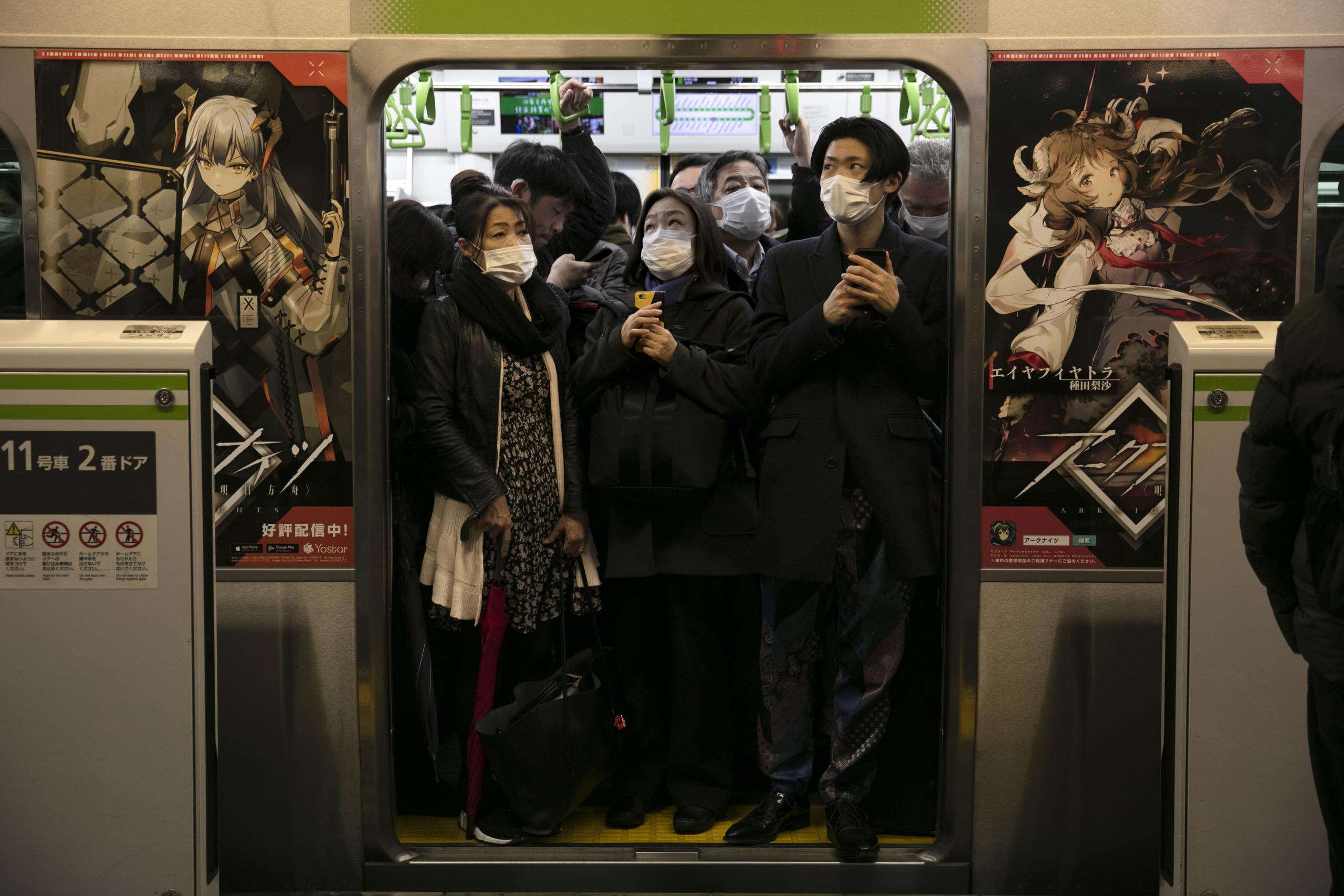 Usuarios del transporte público con máscaras en un tren abarrotado en la estación de Shinagawa, en Tokio.