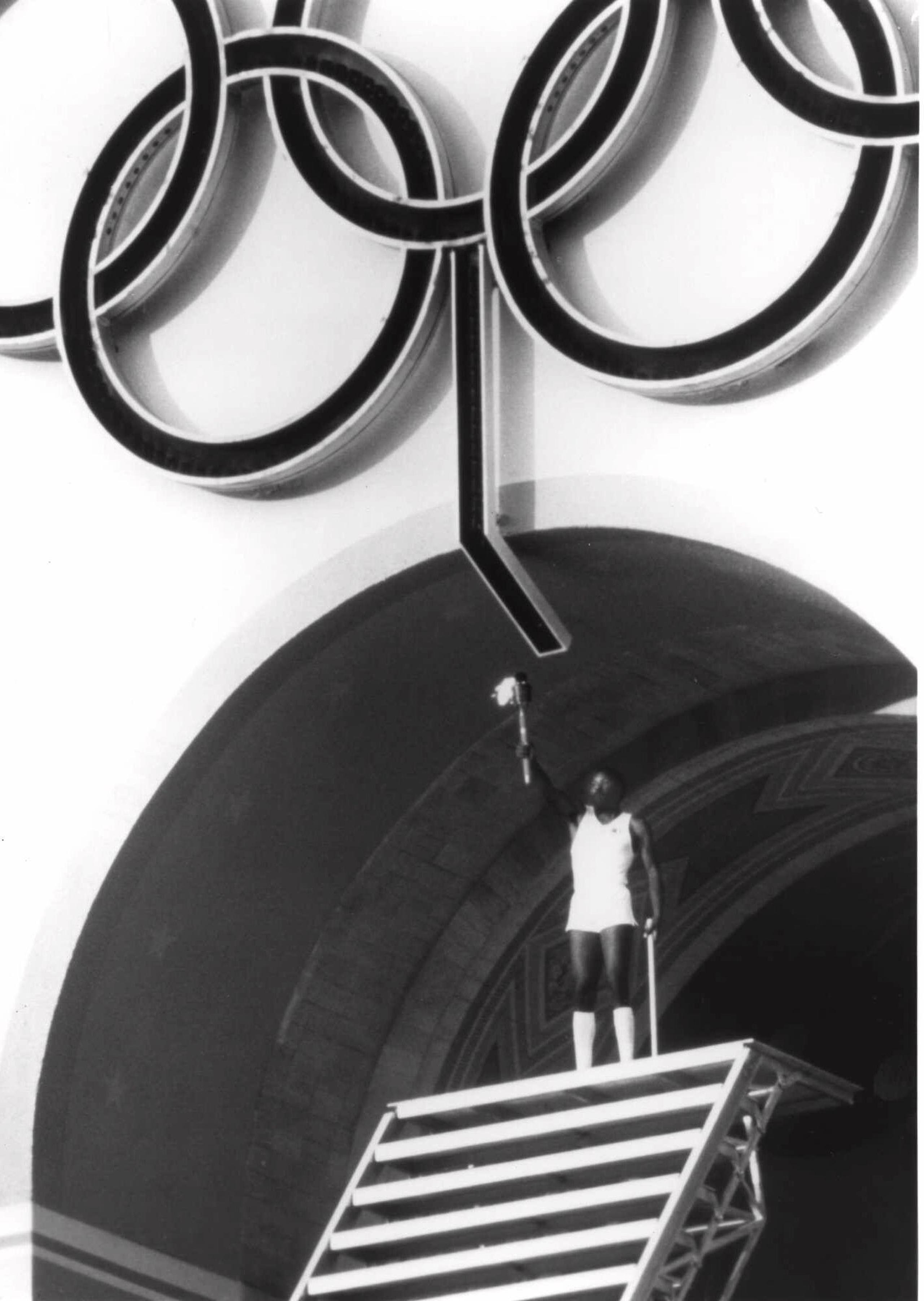 El atleta olímpico Rafer Johnson levanta la antorcha en Los Angeles Memorial Coliseum durante la ceremonia de apertura de los Juegos Olímpicos de 1984.