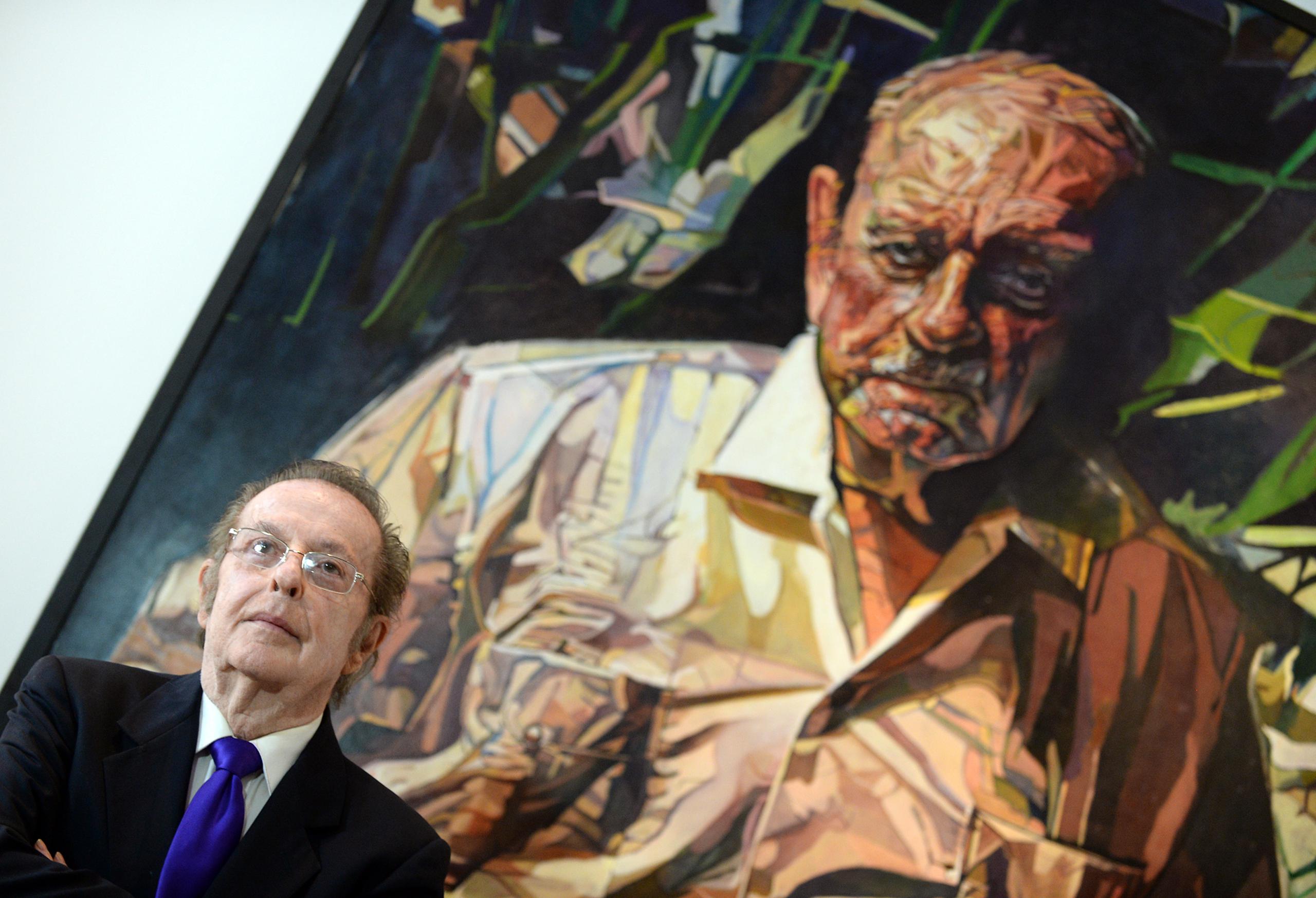 Francisco Rodón posa en el 19 de mayo de 2015 junto a uno de sus cuadros más famosos dedicado a Luis Muñoz Marin en la National Portrait Gallery, en Washington, D. C.