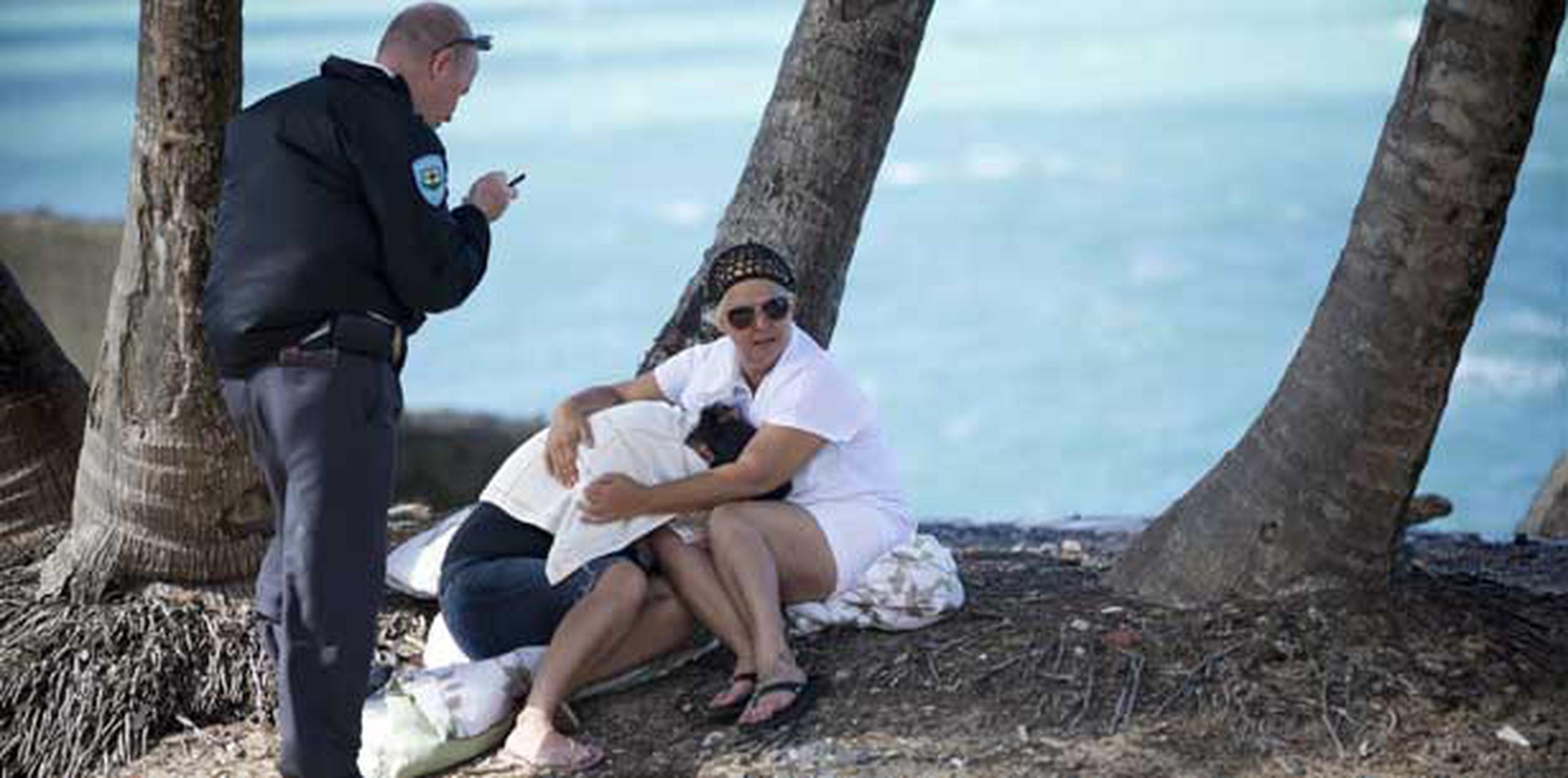 Ana Gómez y Lillian Feliciano, parientes de los ahogados, se abrazan en la playa donde ocurrió la tragedia.  (wandaliz.vega@gfrmedia.com)