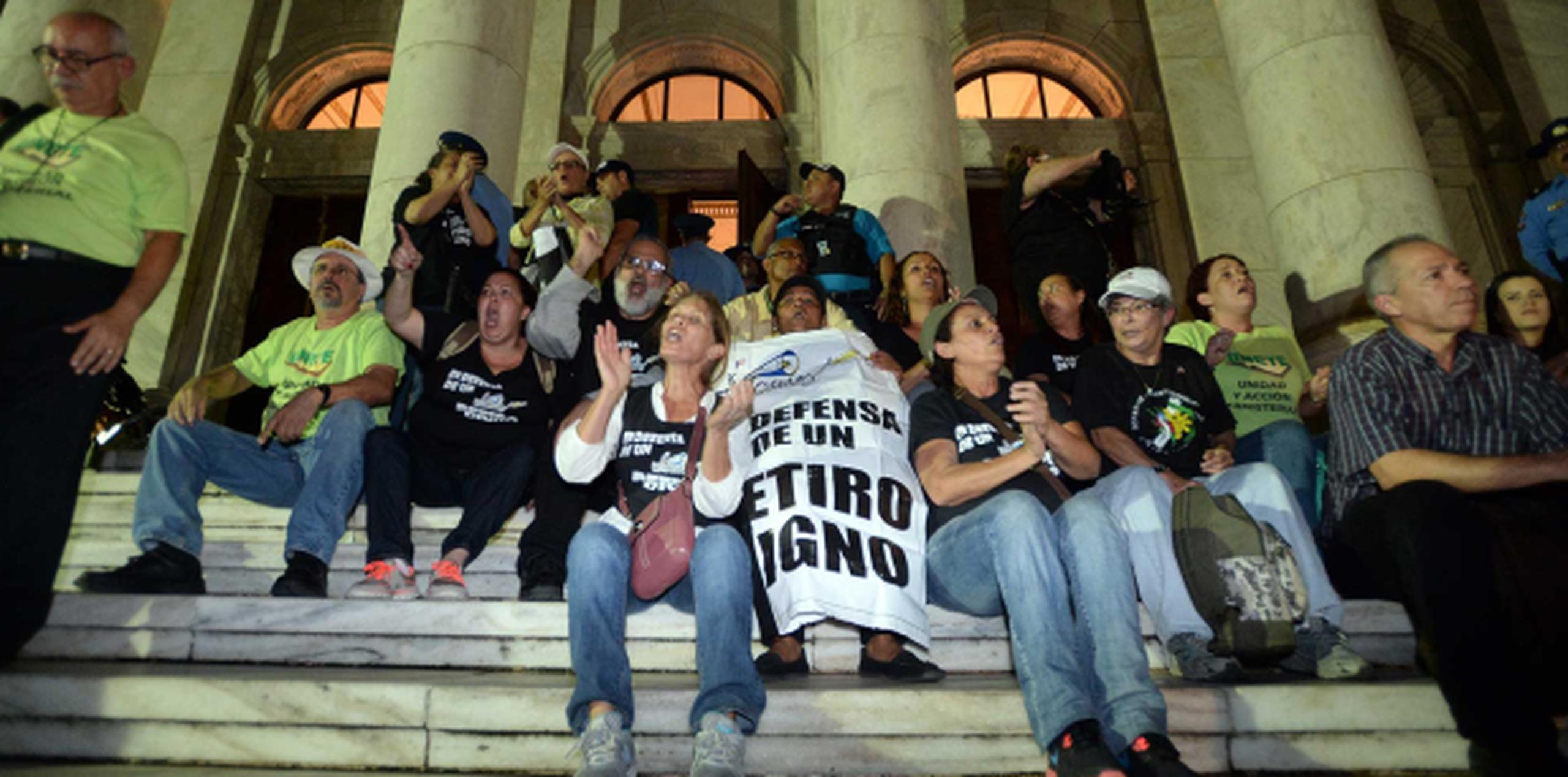 Un grupo de educadores, se sentó en las escalinatas del lado norte, solicitando la salida de las decenas de policías que se apostaron frente a la Casa de las Leyes. (andre.kang@gfrmedia.com)