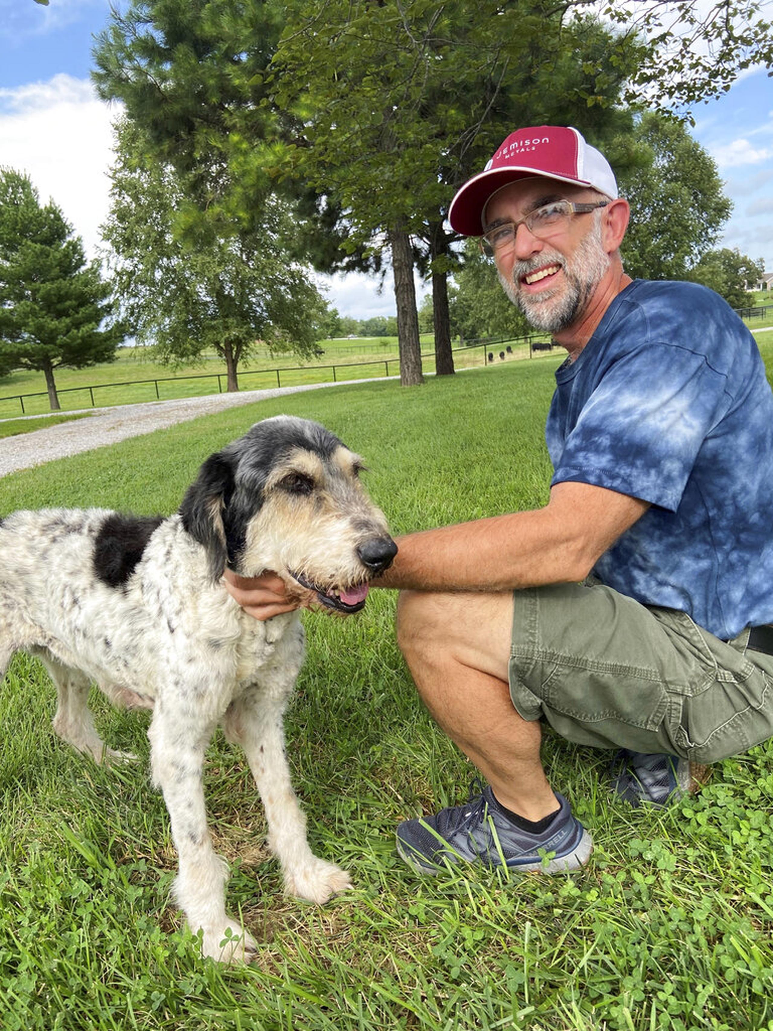 En esta imagen de agosto de 2022 proporcionada por Jeff Bohnert aparece él junto a su perra Abby, quien fue hallada viva en una cueva dos meses después de haber desaparecido.