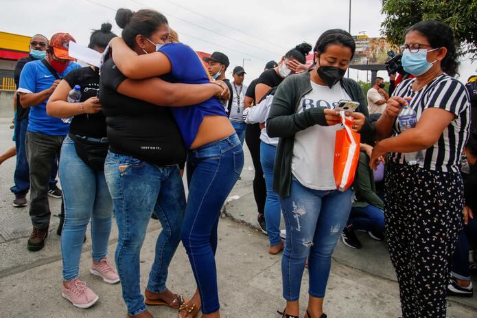 Familiares de reos asesinados se consuelan hoy mientras esperan información de los presos asesinados, en las afueras de la morgue de Guayaquil (Ecuador). EFE/Juan Diego Montenegro
