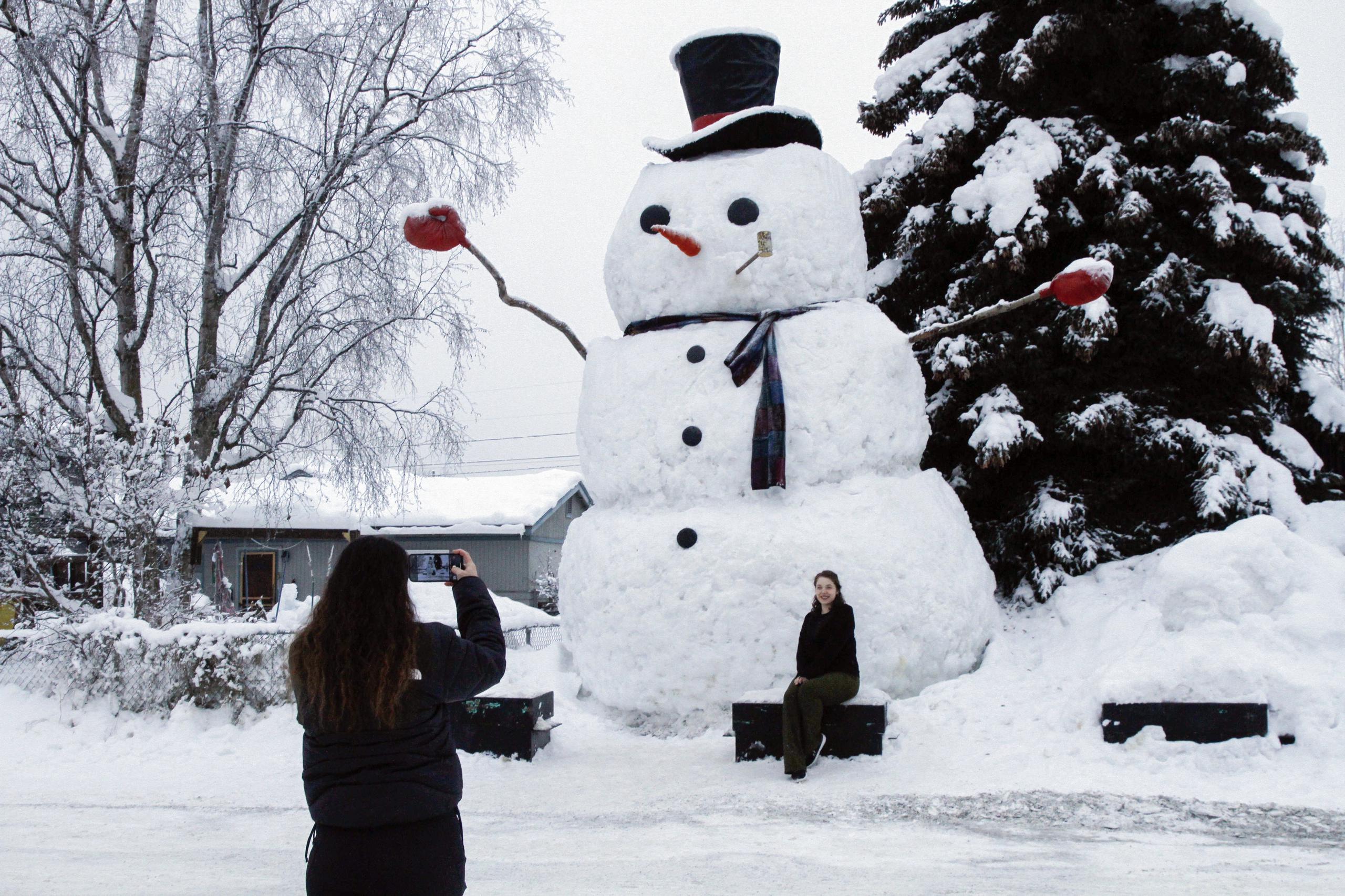 Isil Mico toma una foto de su cuñada Oznur Mico delante de Snowzilla, un muñeco de nieve de más de 6 metros de altura, en Anchorage, Alaska.