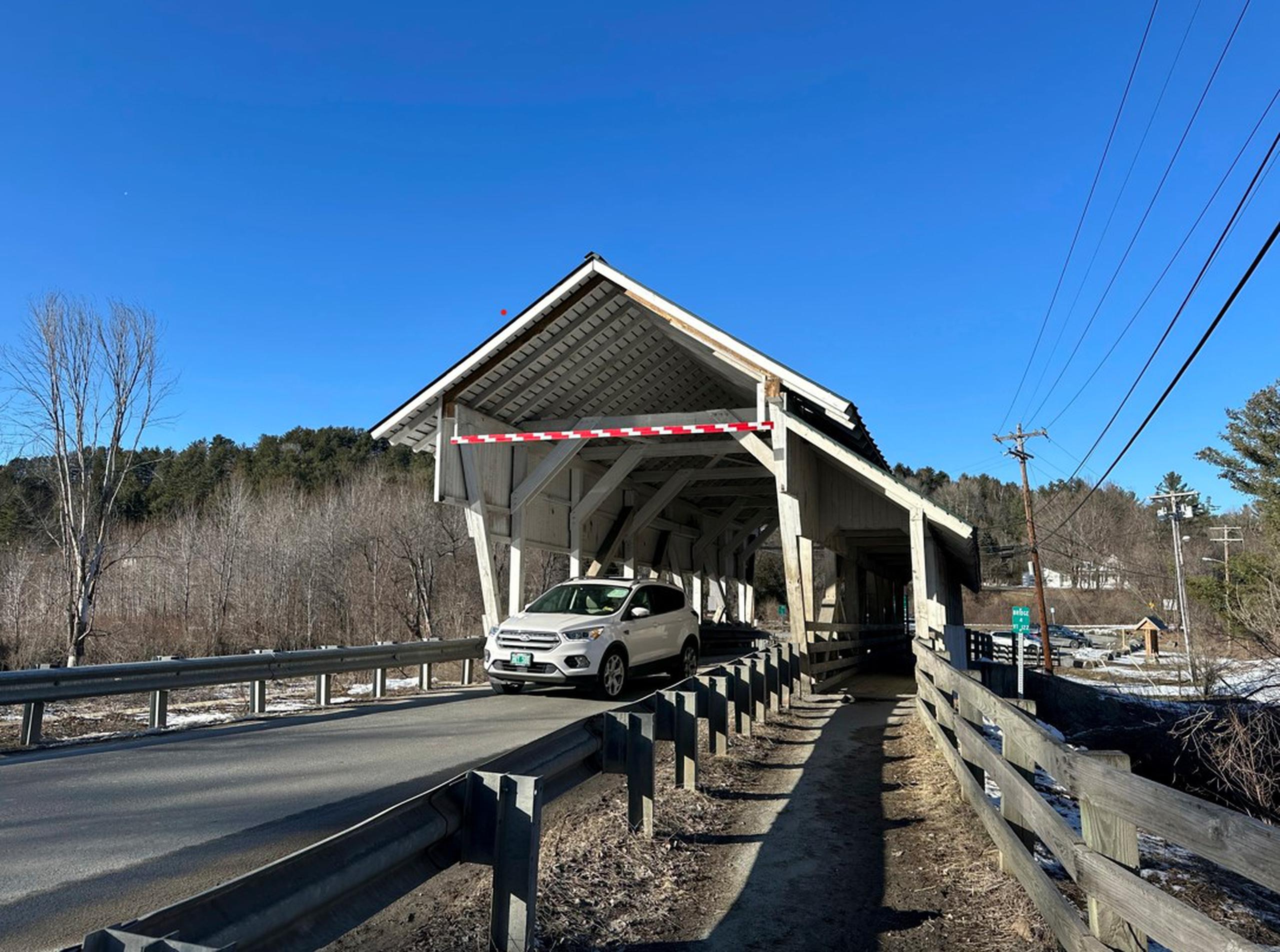 Un vehículo pasa por el puente cubierto Miller's Run en Lyndon, Vermont.